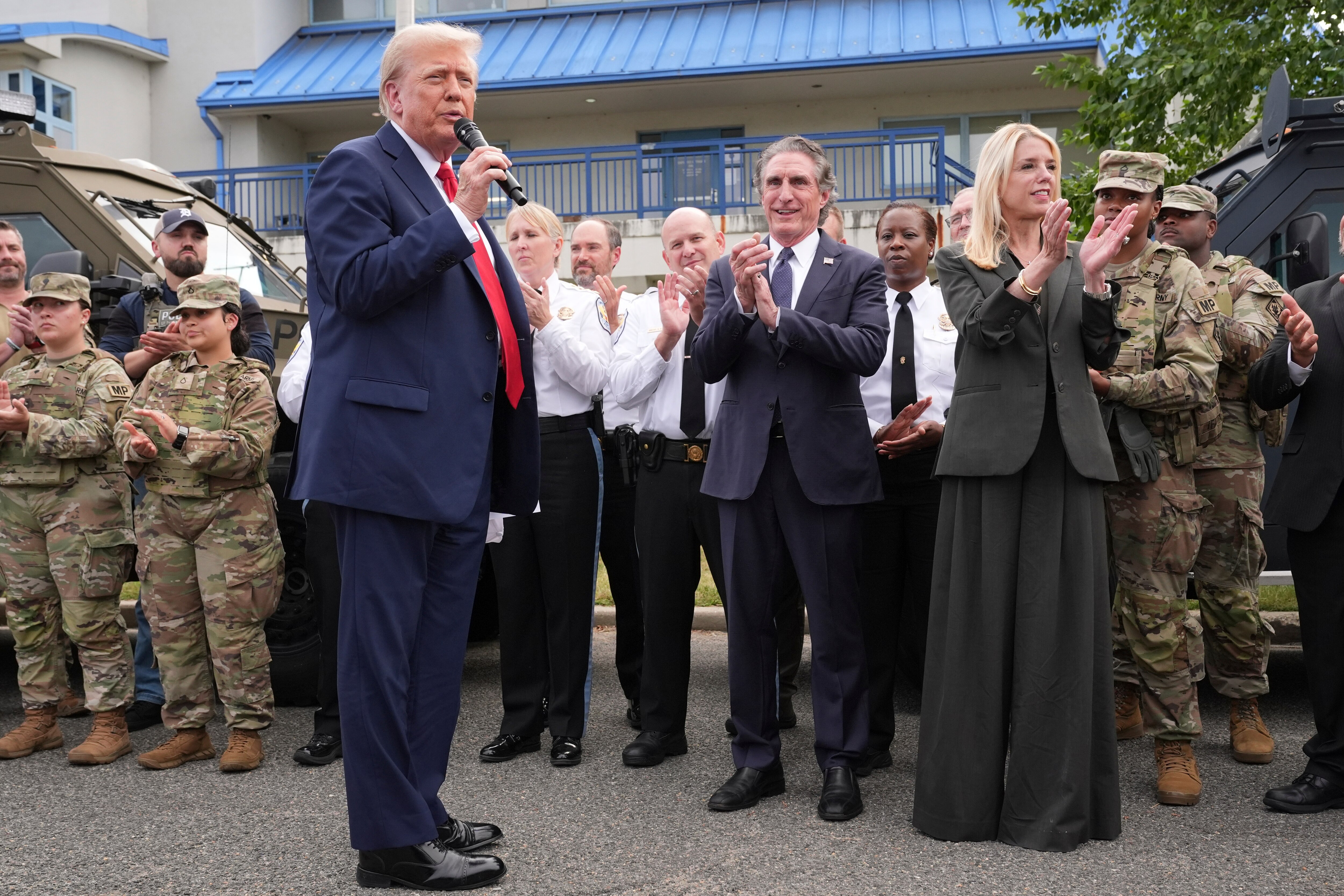 President Donald Trump speaks with members of law enforcement and National Guard soldiers, Thursday, Aug. 21, 2025, in Washington, as Interior Secretary Doug Burgum and Attorney General Pam Bondi listen.