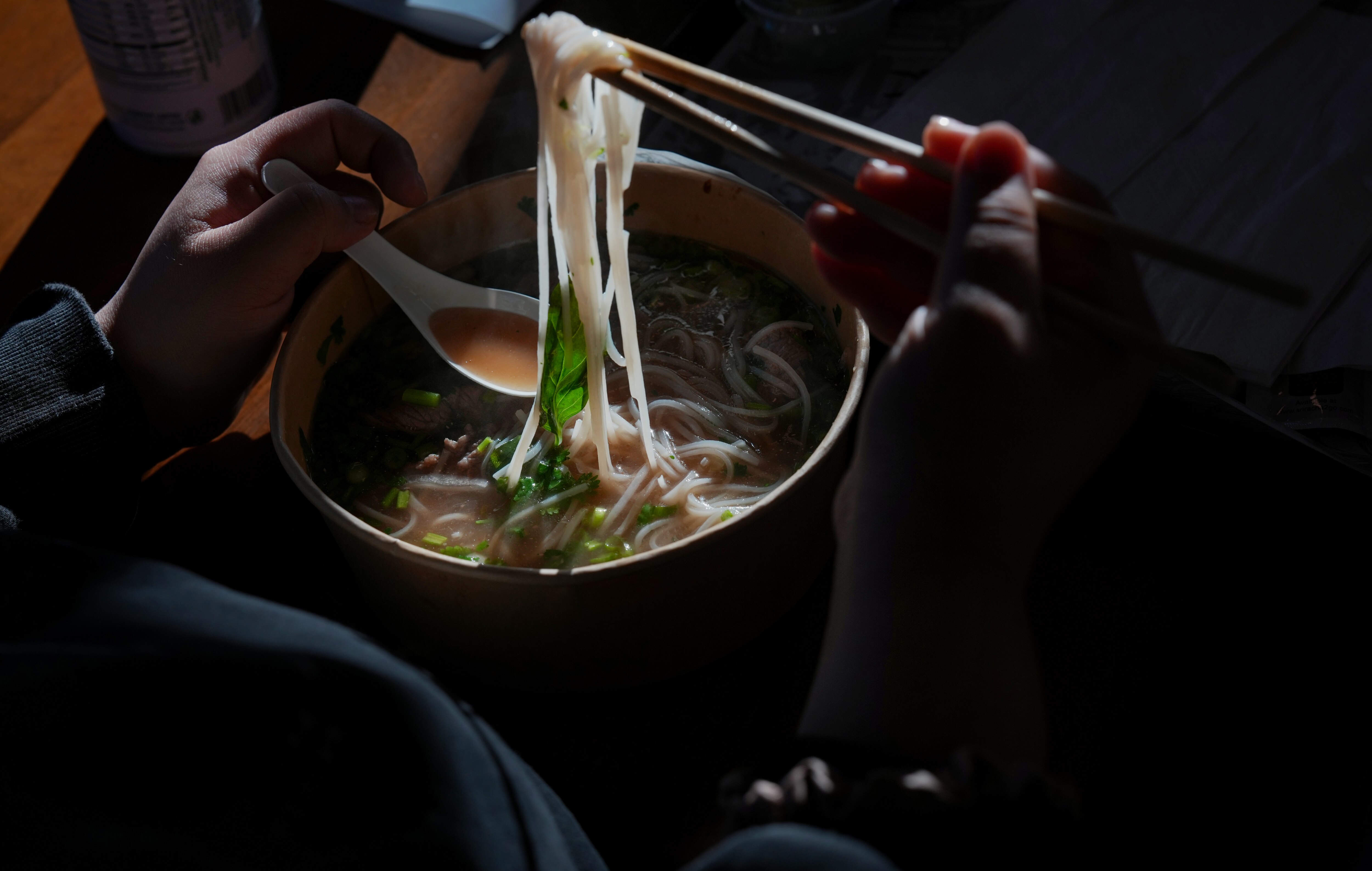 A customer eats a bowl of brisket pho at PhoWheels in Burtonsville.