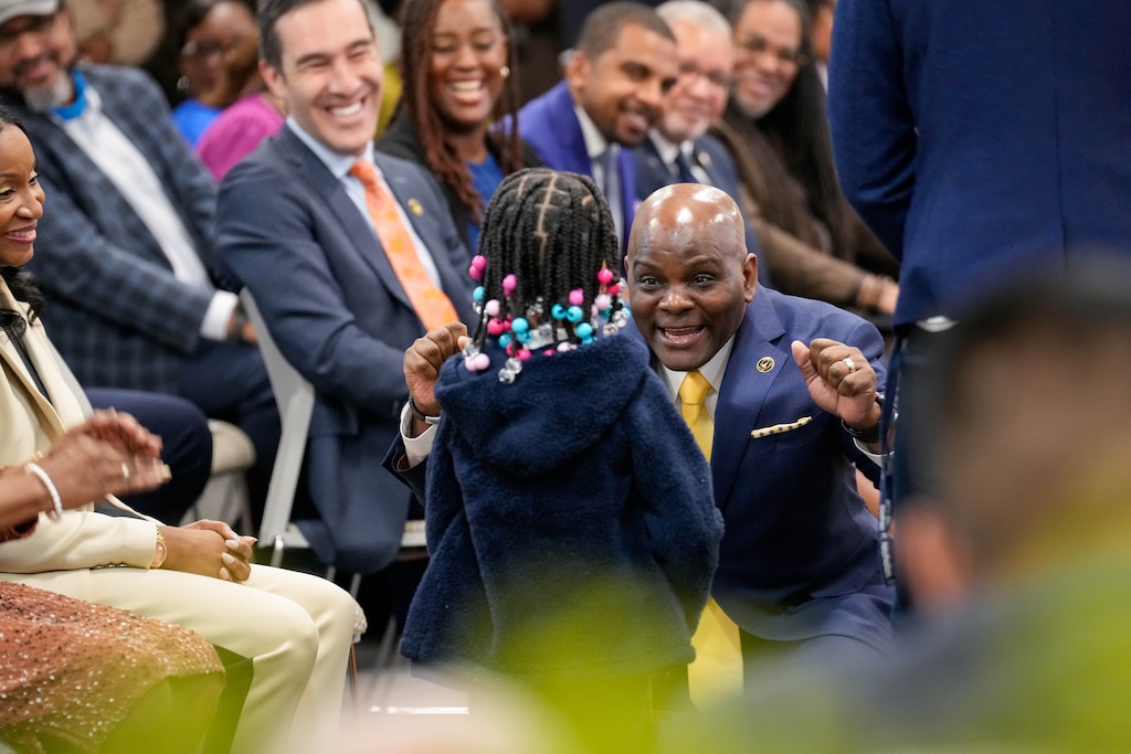 Incoming City Schools CEO Dr. Jermaine Dawson, center, bends down cheering to accept a gift from a young student who attended the Baltimore City Board of School Commissioners vote to approve him at the Baltimore City Public Schools headquarters in Baltimore, Md. on Monday, April 20, 2026.