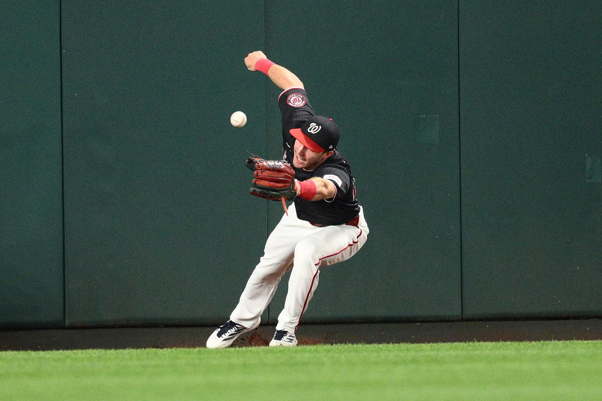 Washington Nationals center fielder Jacob Young tries to field a ball that went for a triple by Seattle Mariners' Dominic Canzone during the second inning of a baseball game, Friday, June 12, 2026, in Washington.