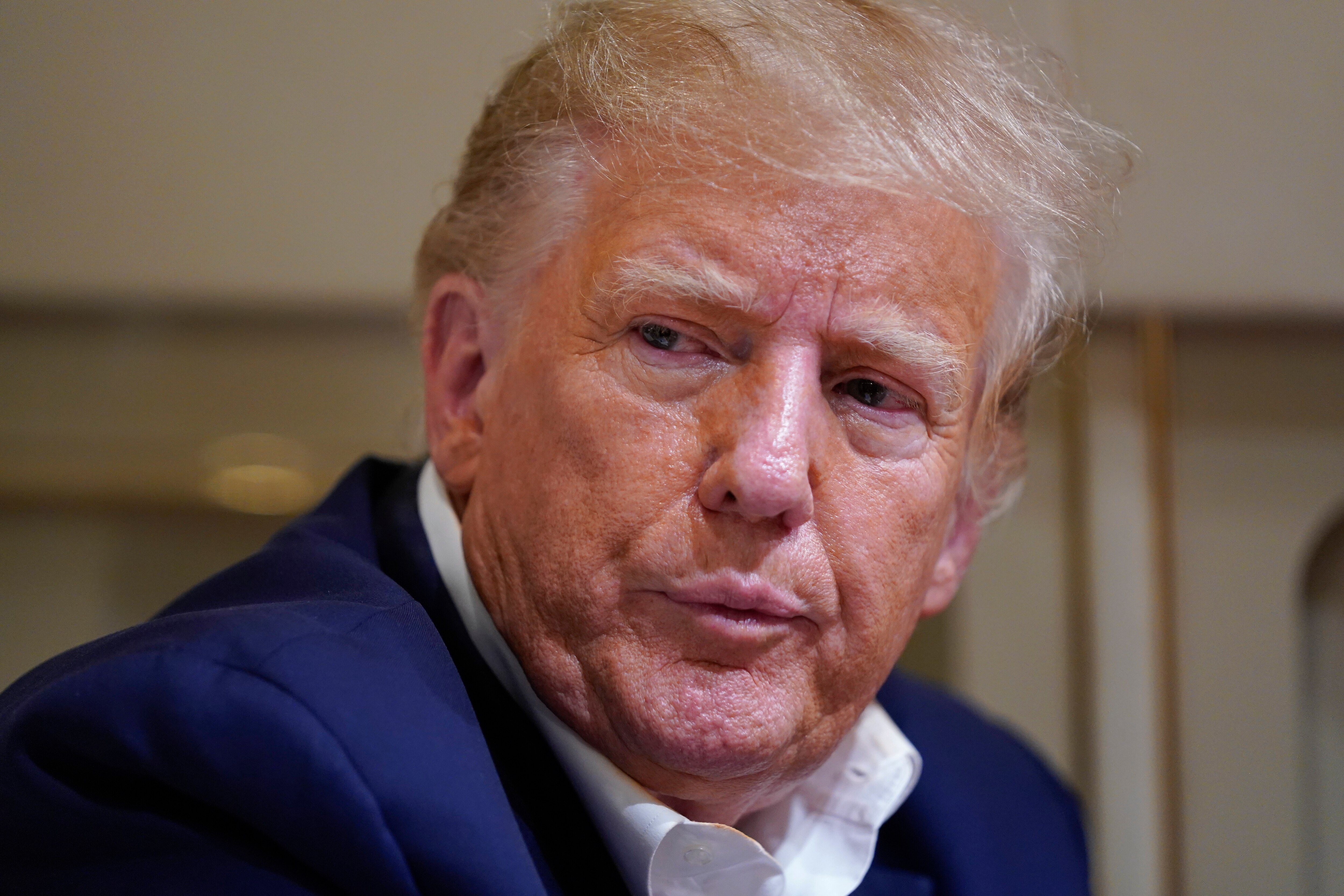 Former President Donald Trump listens as he speaks with reporters while in flight on his plane after a campaign rally at Waco Regional Airport, in Waco, Texas, Saturday, March 25, 2023, while en route to West Palm Beach, Fla.