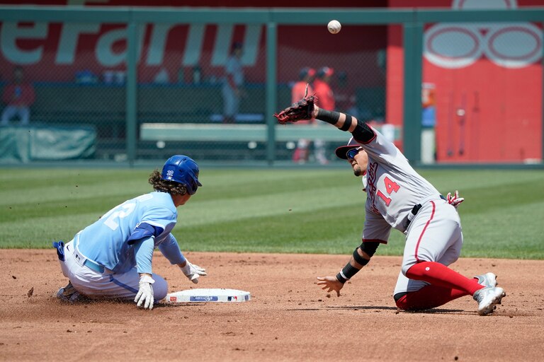 KANSAS CITY, MISSOURI - MAY 28: Nick Pratto #32 of the Kansas City Royals slides into second for a double past Ildemaro Vargas #14 of the Washington Nationals in the first inning at Kauffman Stadium on May 28, 2023 in Kansas City, Missouri.