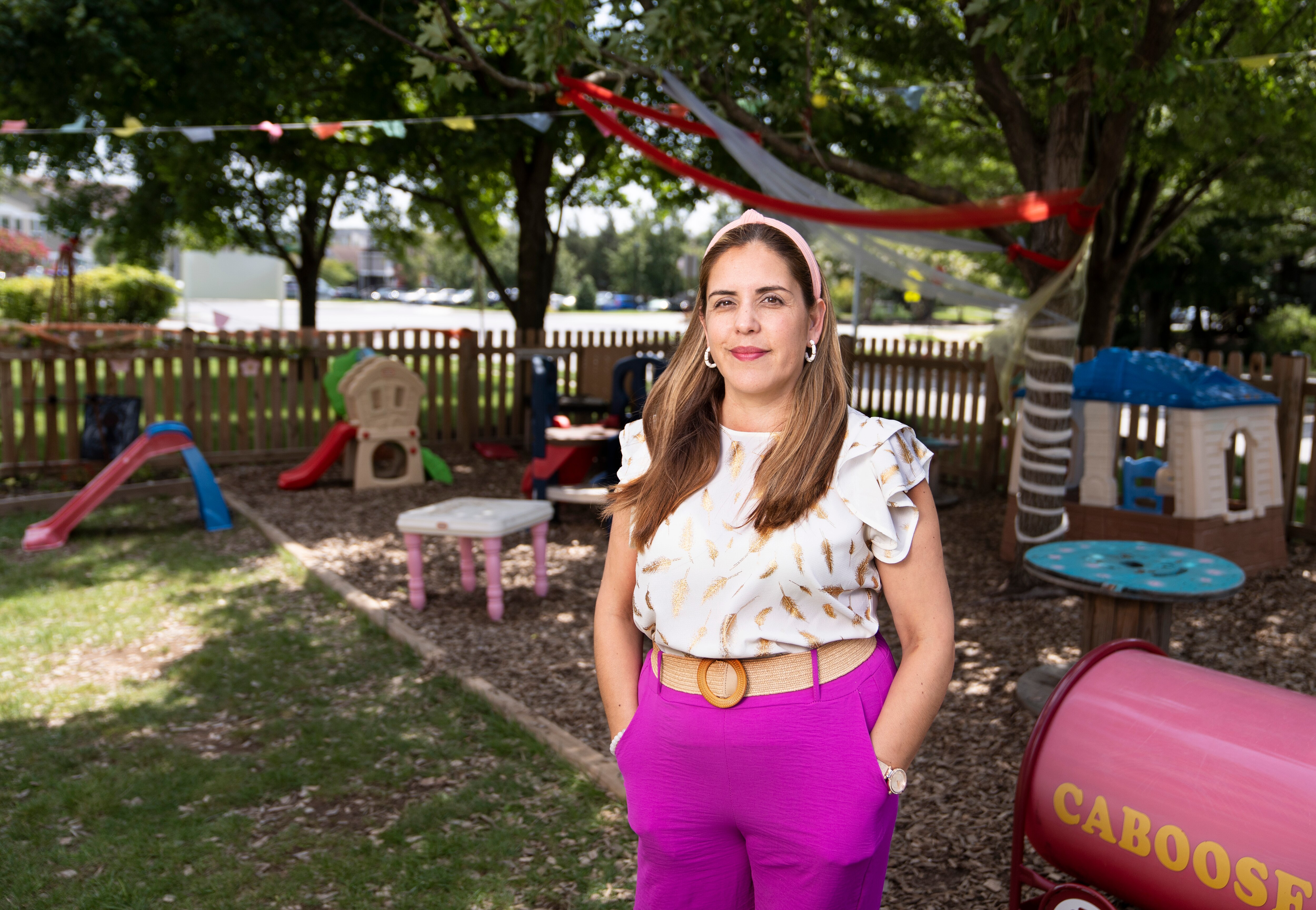 Carolina Reyes, Director of Arco Iris Bilingual Children’s Center in Laurel, poses for a portrait near an outdoor play area outside the center, Wednesday, Aug. 9, 2023.