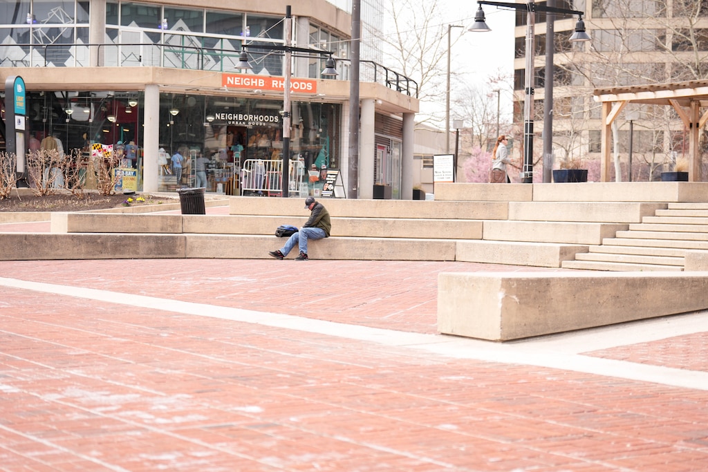 A sparse number of pedestrians sit in the amphitheater and meander through Harborplace at lunchtime at the Inner Harbor in Baltimore, Md., on Wednesday, March 25, 2026.