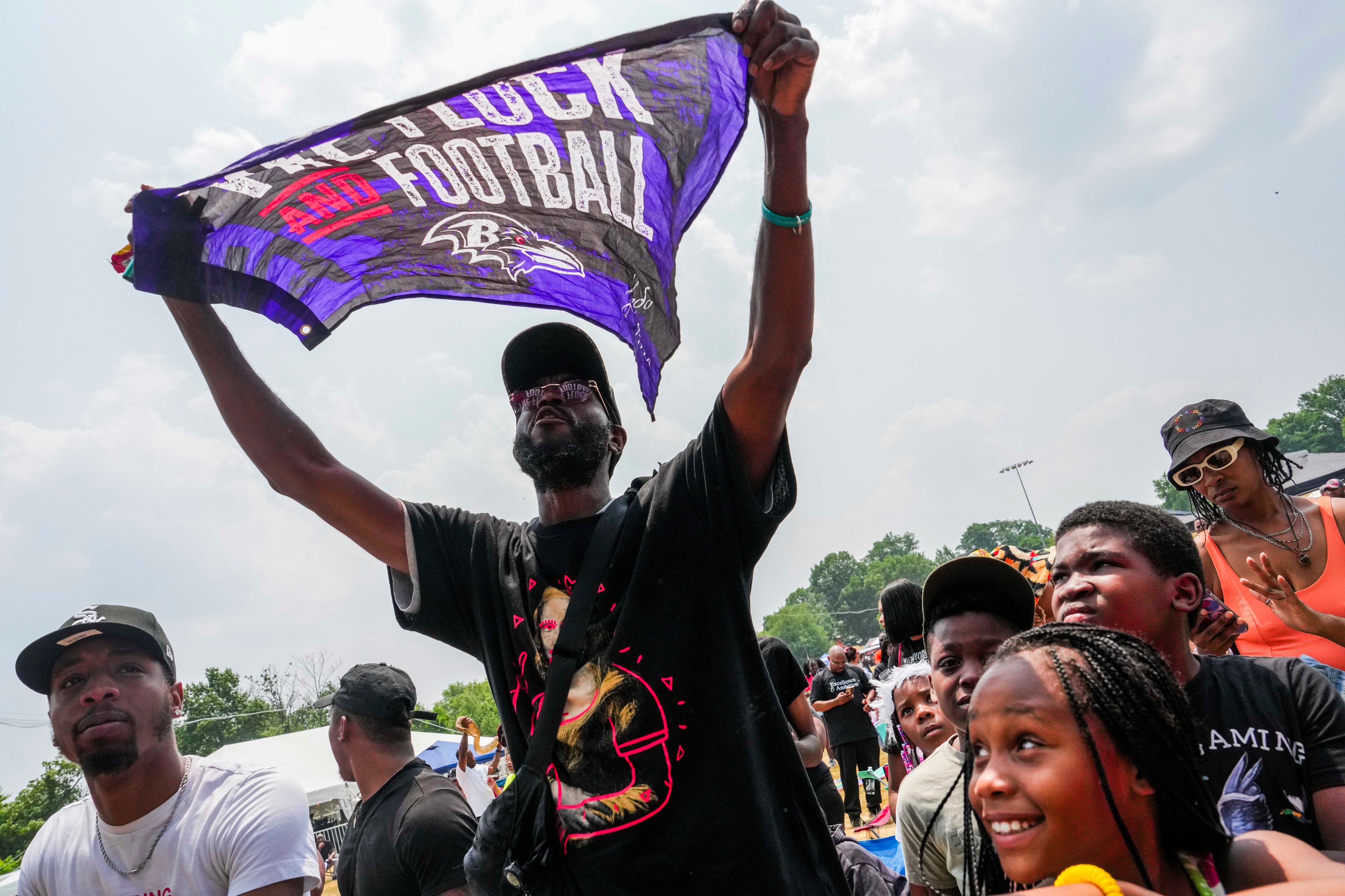 Marvin Parrott, 37, waves a Ravens flag at AFRAM Juneteenth Festival on June 17, 2023 at Druid Hill Park. This is the first official Baltimore Club Music Day. 