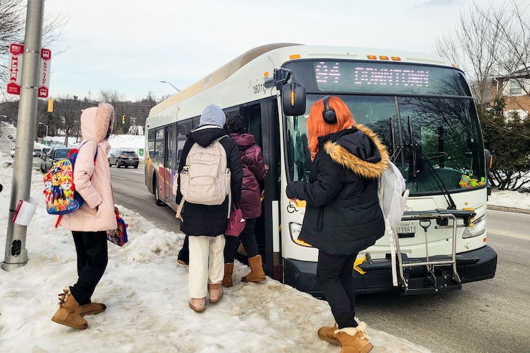Students wait to board a public bus near Western High School off Falls Road after school on Tuesday.