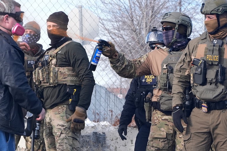 An Immigration and Customs Enforcement (ICE) agent shoots pepper spray at a protester outside of the Bishop Whipple Federal Building, Monday, Jan. 12, 2026, in Minneapolis.