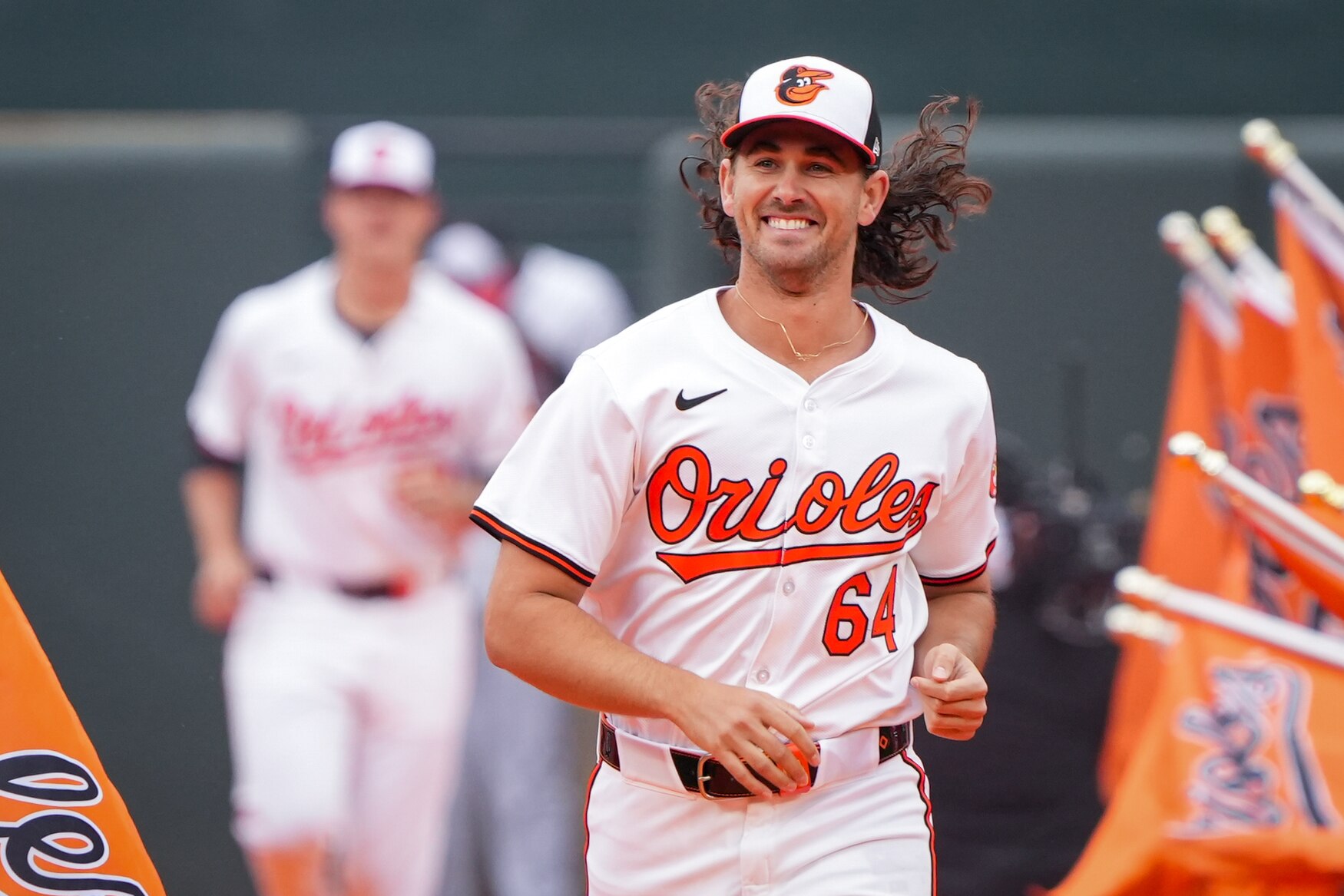Baltimore Orioles starting pitcher Dean Kremer (64) runs down the orange carpet on opening day at Camden Yards.