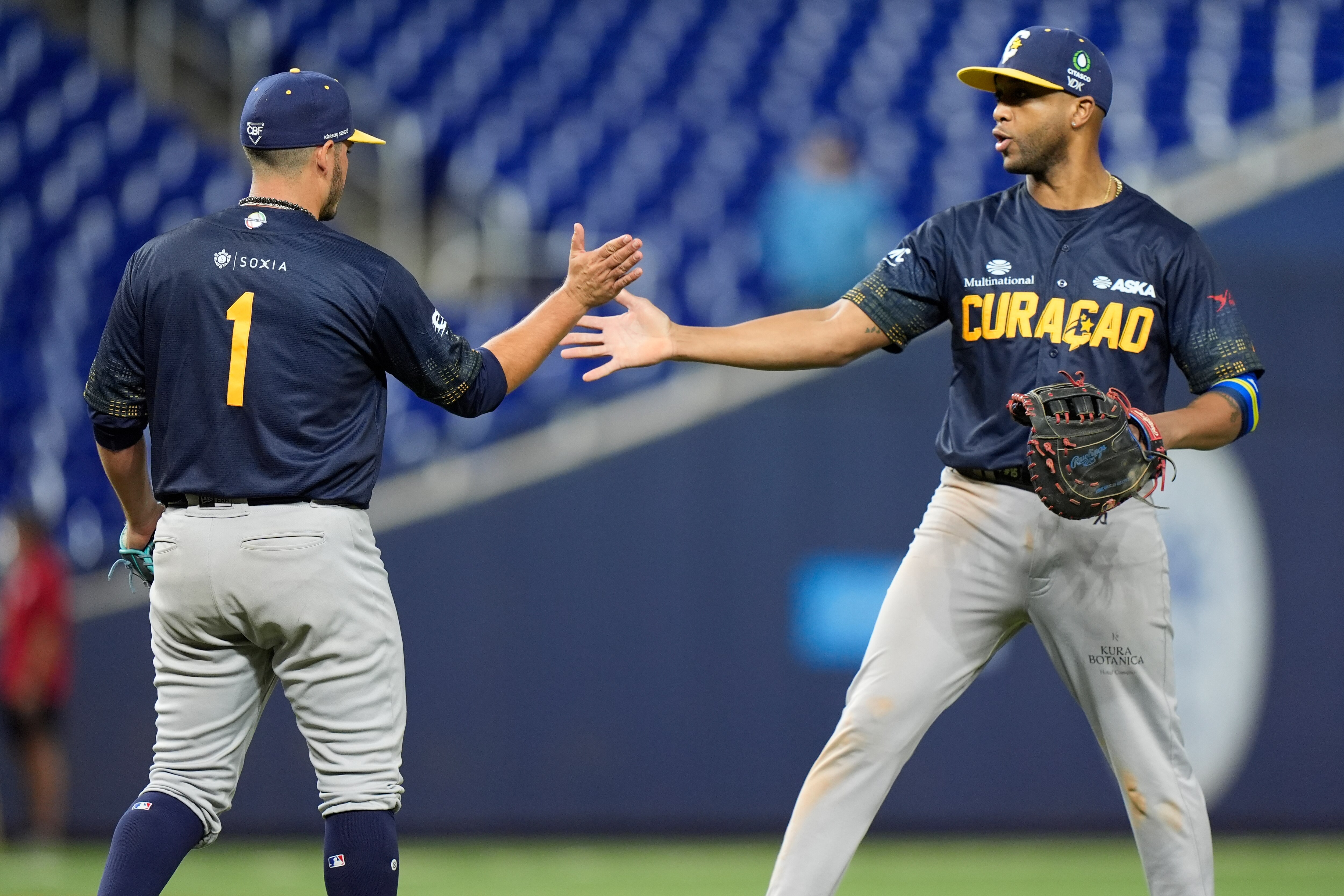 Curacao relief pitcher Anthony Herrera (1) and infielder Sharlon Schoop celebrate after Curacao beat Mexico, 6-5, during a Caribbean Series game in 2024.