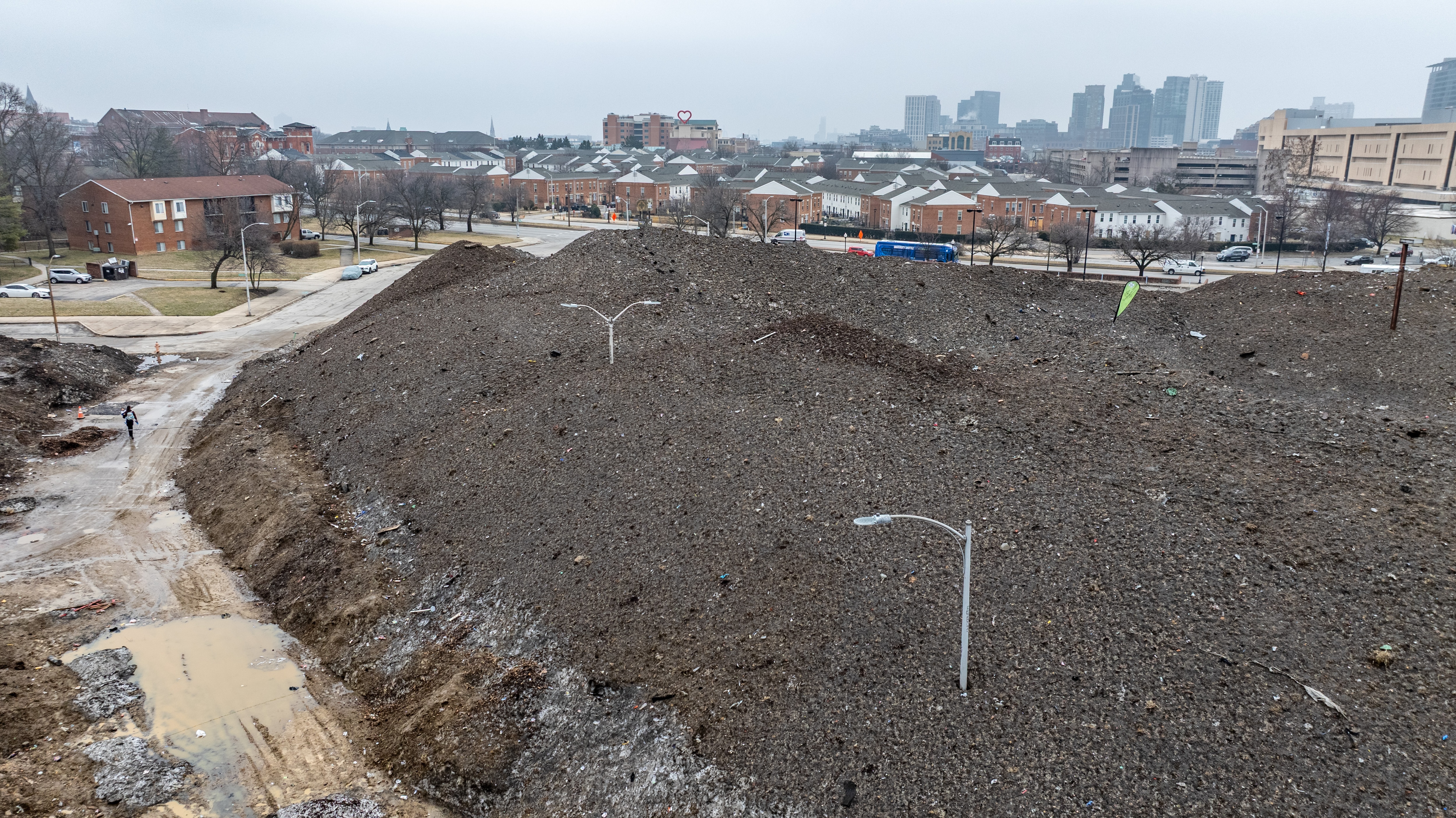 Light poles stick out of the massive pile of snow and debris in the Old Town Mall parking lot in East Baltimore in March. 