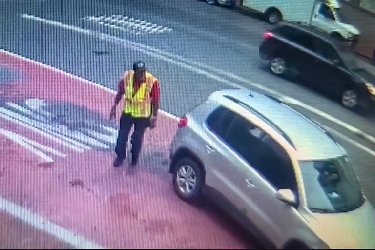 Screenshot from surveillance footage shows a driver getting out to check his vehicle for damage before driving away after striking a woman walking in downtown Baltimore on Sept. 3, 2026.