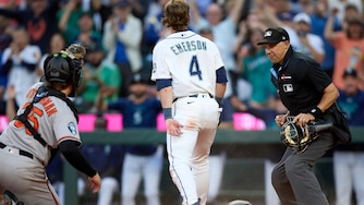 Seattle Mariners' Colt Emerson scores ahead of the tag from Baltimore Orioles catcher Adley Rutschman during the seventh inning.