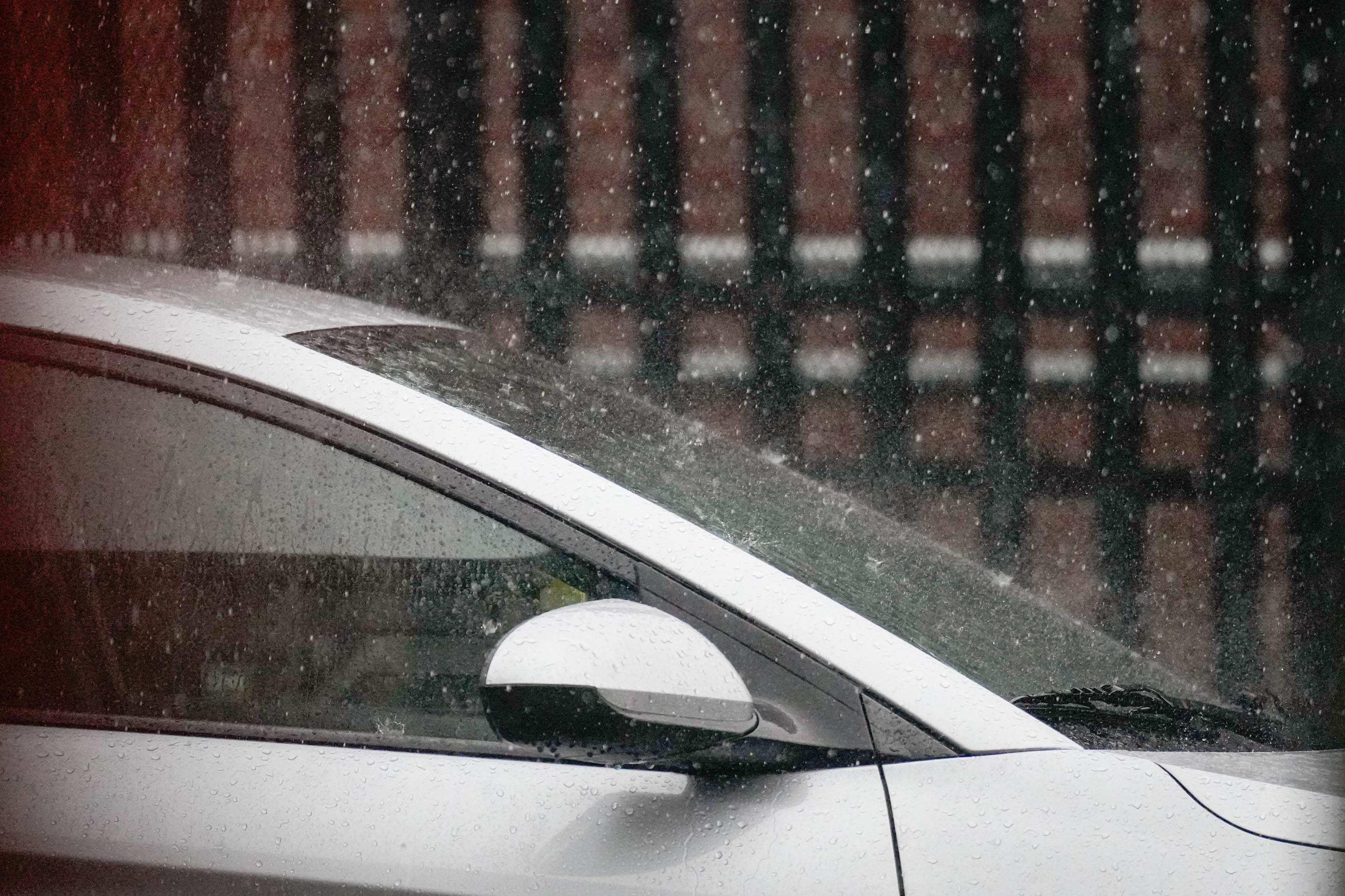 Rains splashes a car as a thunderstorm hits during a jiu jitsu lesson at Guardian Baltimore, a non-profit martial arts studio, in Baltimore, Md. on Thursday, July 31, 2025.