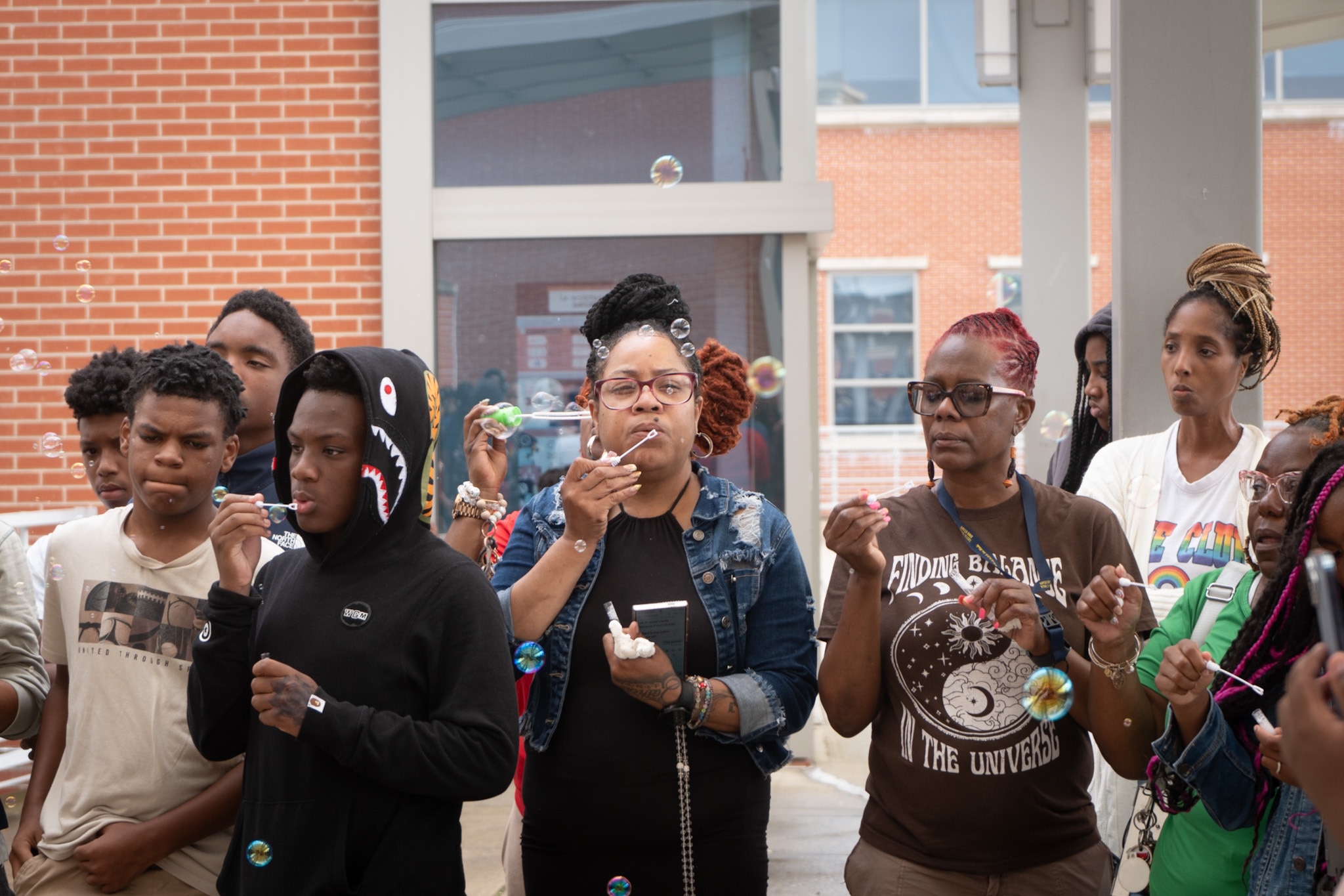 Friends and family of Cortez Lemon Jr. blow bubbles to honor the 14-year-old stabbing victim following a vigil at Leith Walk Elementary Middle School on July 22, 2024.