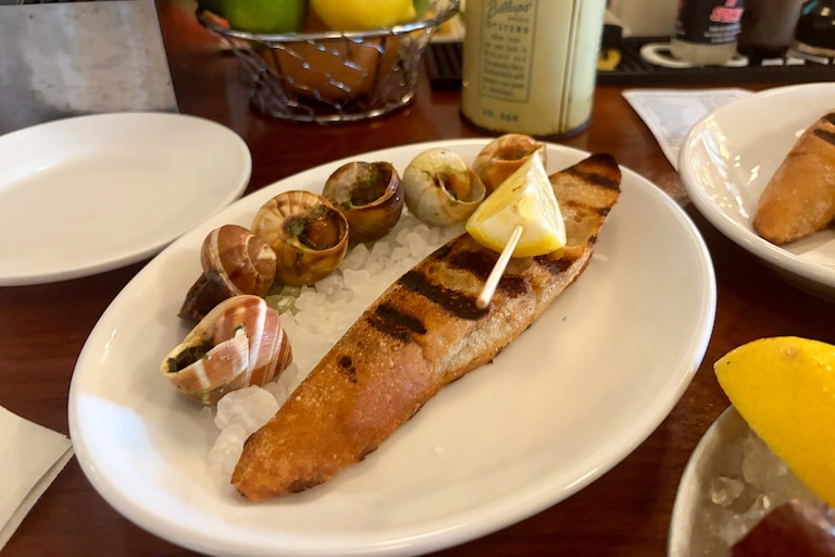 Escargots are served warm with maître d'hôtel butter, lemon and a slice of grilled baguette at Thames Street Oyster House.