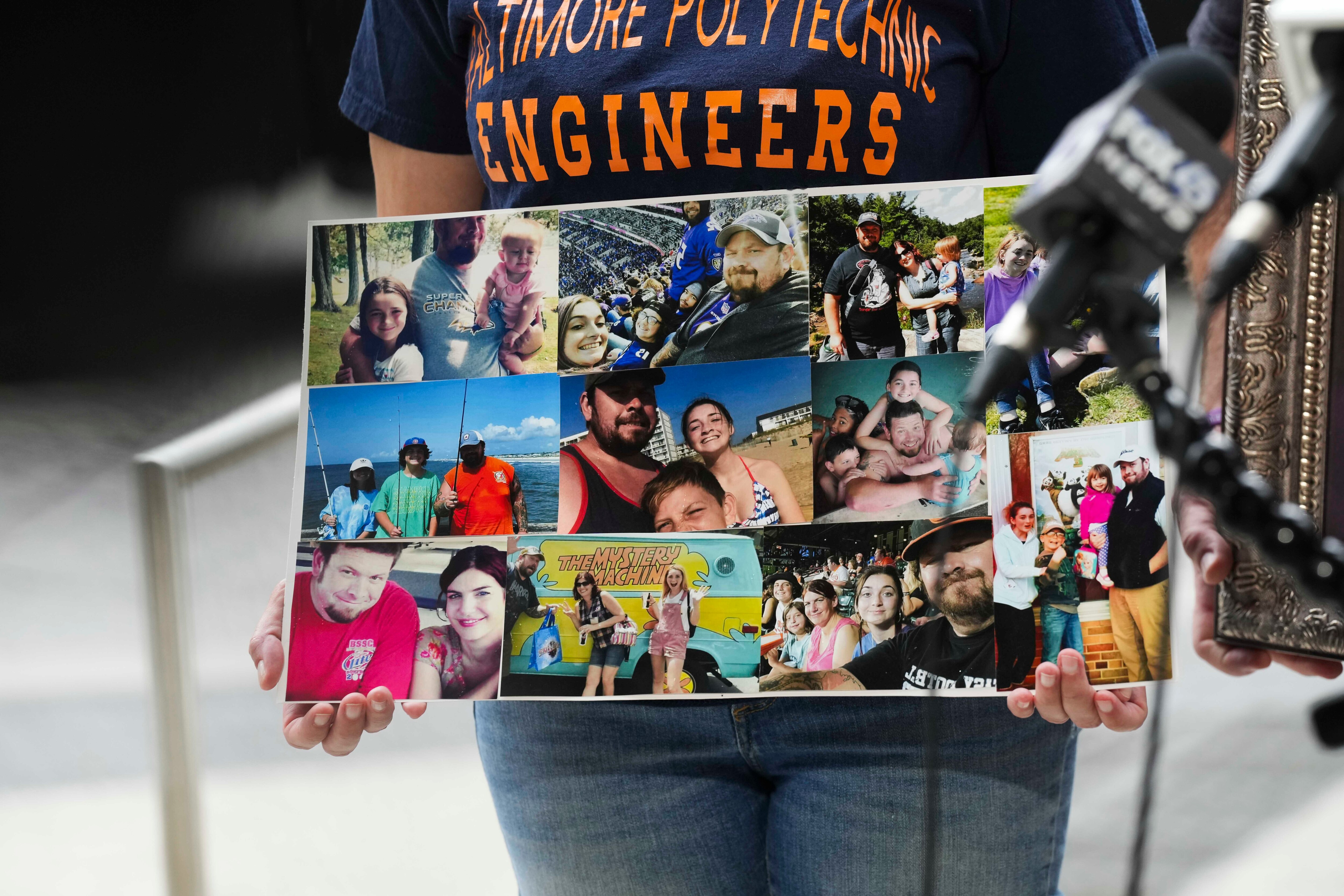 Shannon Reynolds, Timothy Reynolds’ widow, holds up a board containing several family photos of her late husband, who was shot and killed after confronting a group of squeegee workers with a baseball bat at the intersection of Light and Conway streets near the Inner Harbor on July 7, 2022. A 16-year-old is standing trial this week in Baltimore Circuit Court on charges including first-degree murder in his killing.