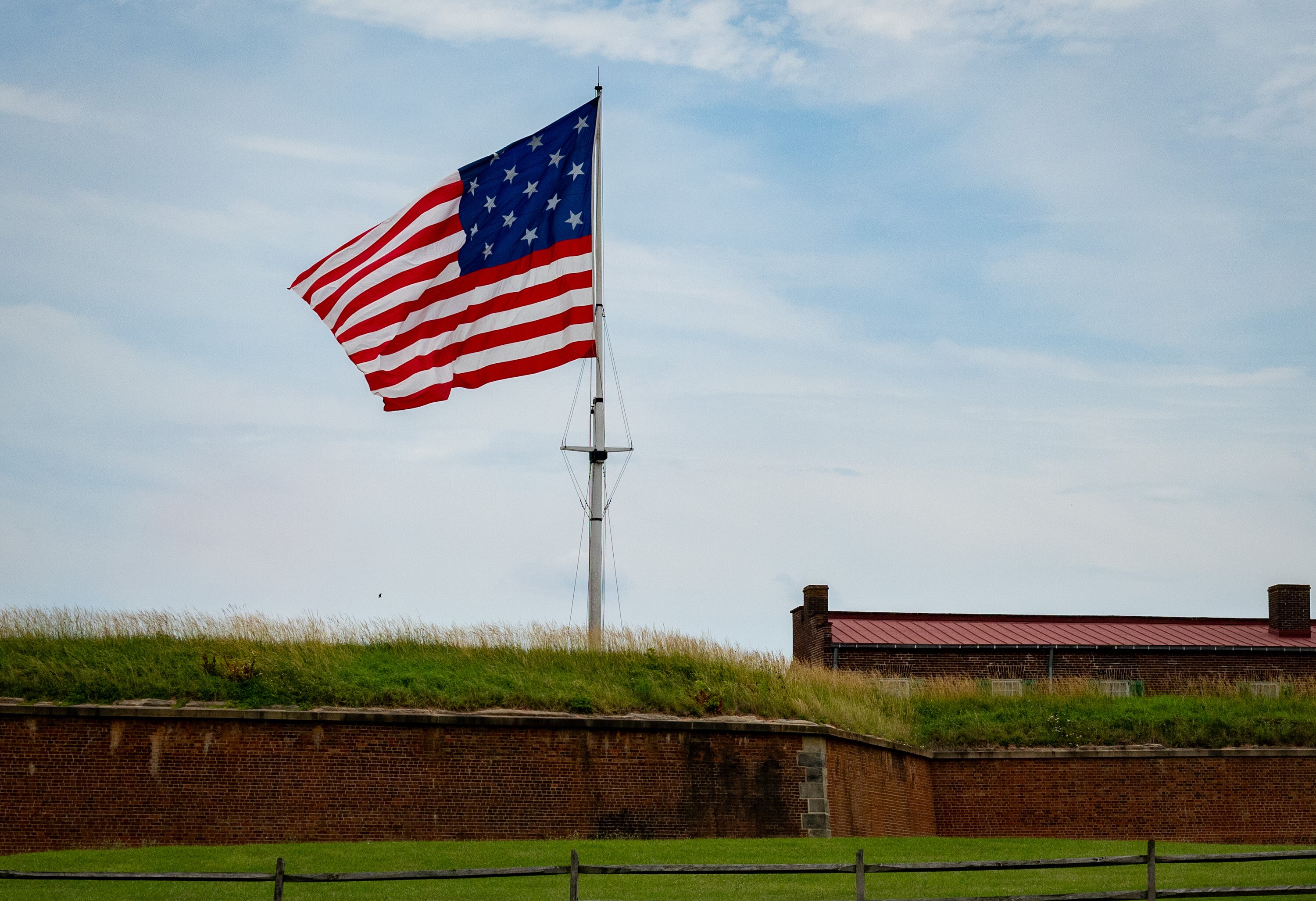 A flag with 15 stars and 15 stripes flies over Fort McHenry.