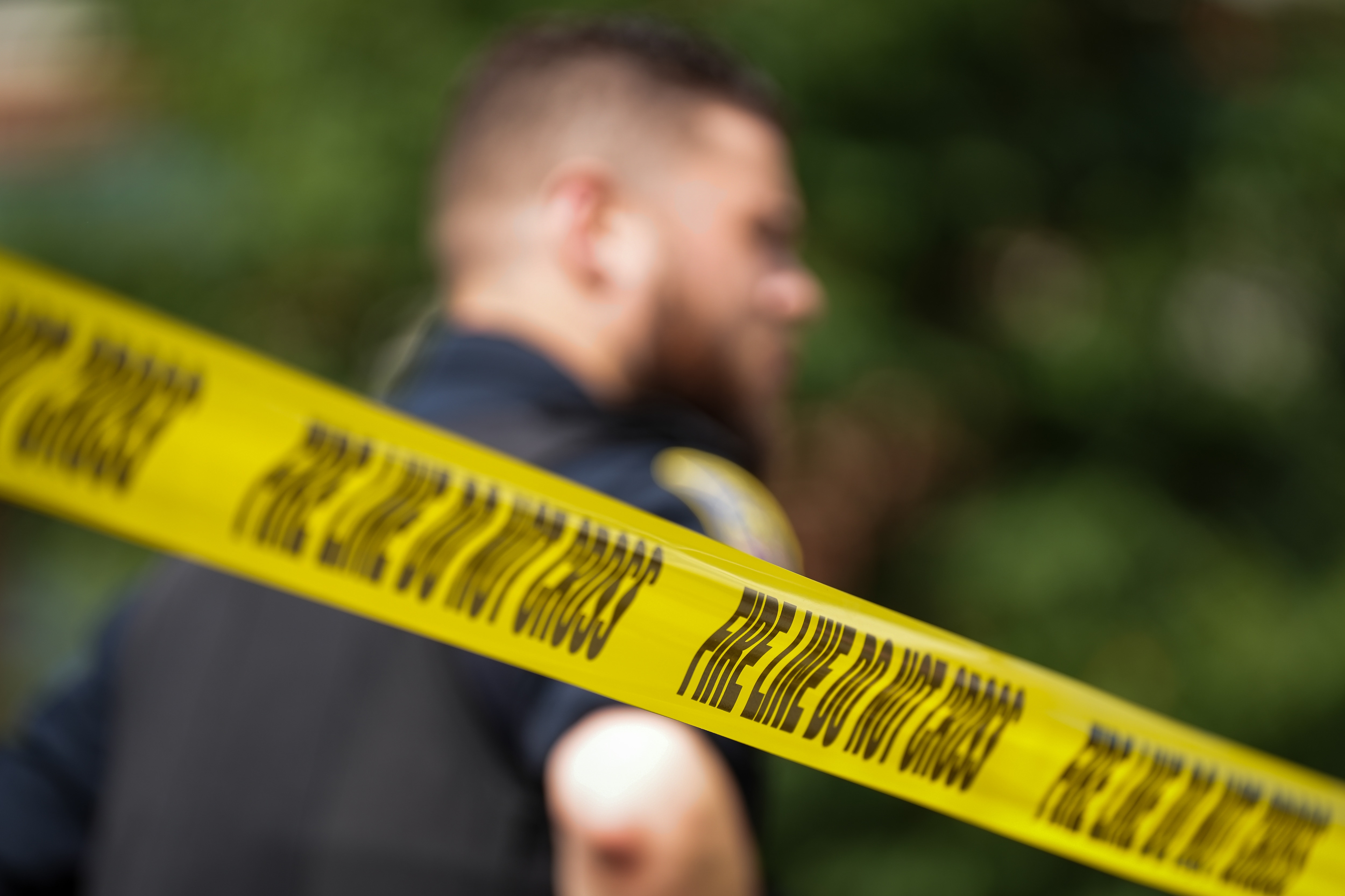 A police officer stands near crime scene tape in July 2022.