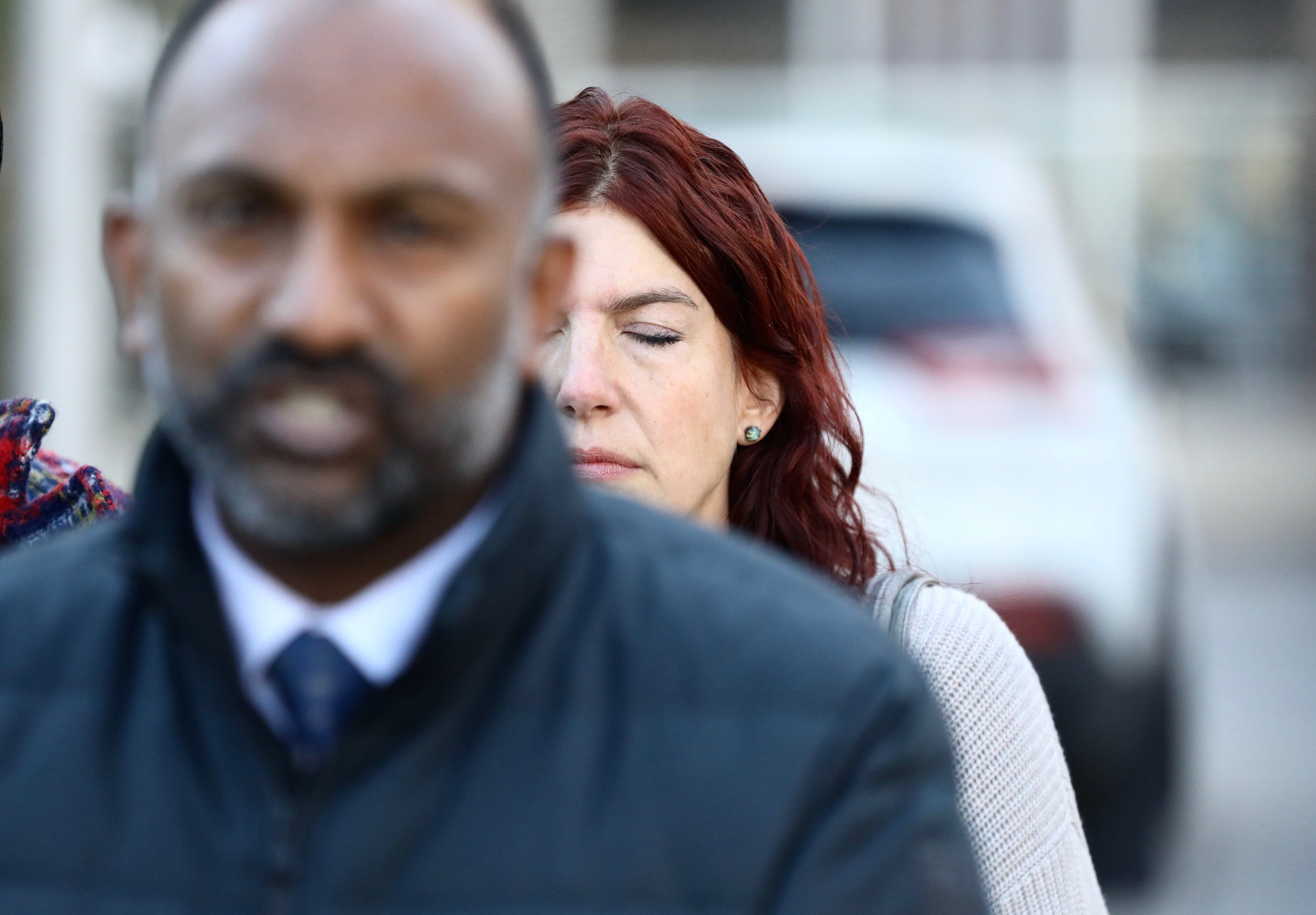 Thiru Vignarajah, an attorney for the family of Timothy Reynolds, is pictured on Monday at a news conference behind the War Memorial in Baltimore. Reynolds’ wife, Shannon, is seen behind him. The Baltimore State’s Attorney’s Office and defense attorneys for a 15-year-old who’s accused of shooting and killing Reynolds on July 7 at the intersection of Light and Conway streets near the Inner Harbor have reached a verbal agreement on a plea offer that would call for the case to be handled in juvenile court — over the objections of his loved ones.