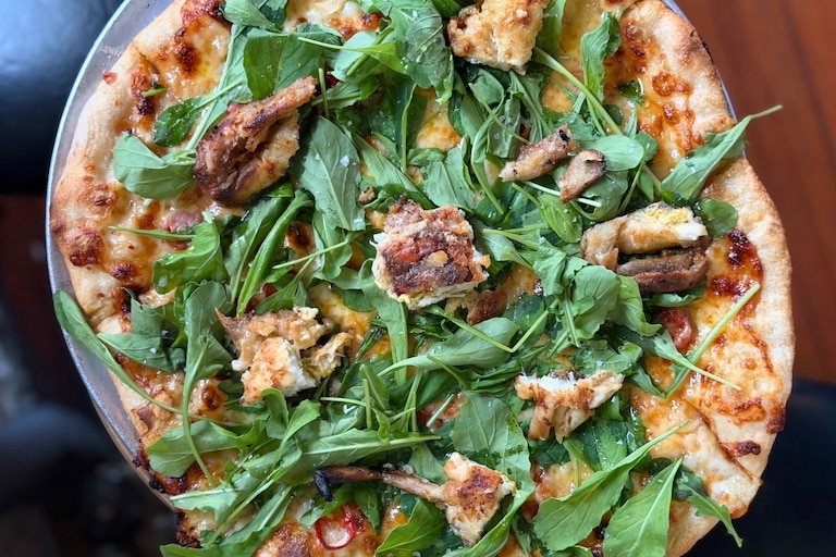 Little Donna's soft-shell crab tavern pie has housemade stracciatella, sliced garlic, Fresno chile, hot honey and wild arugula.