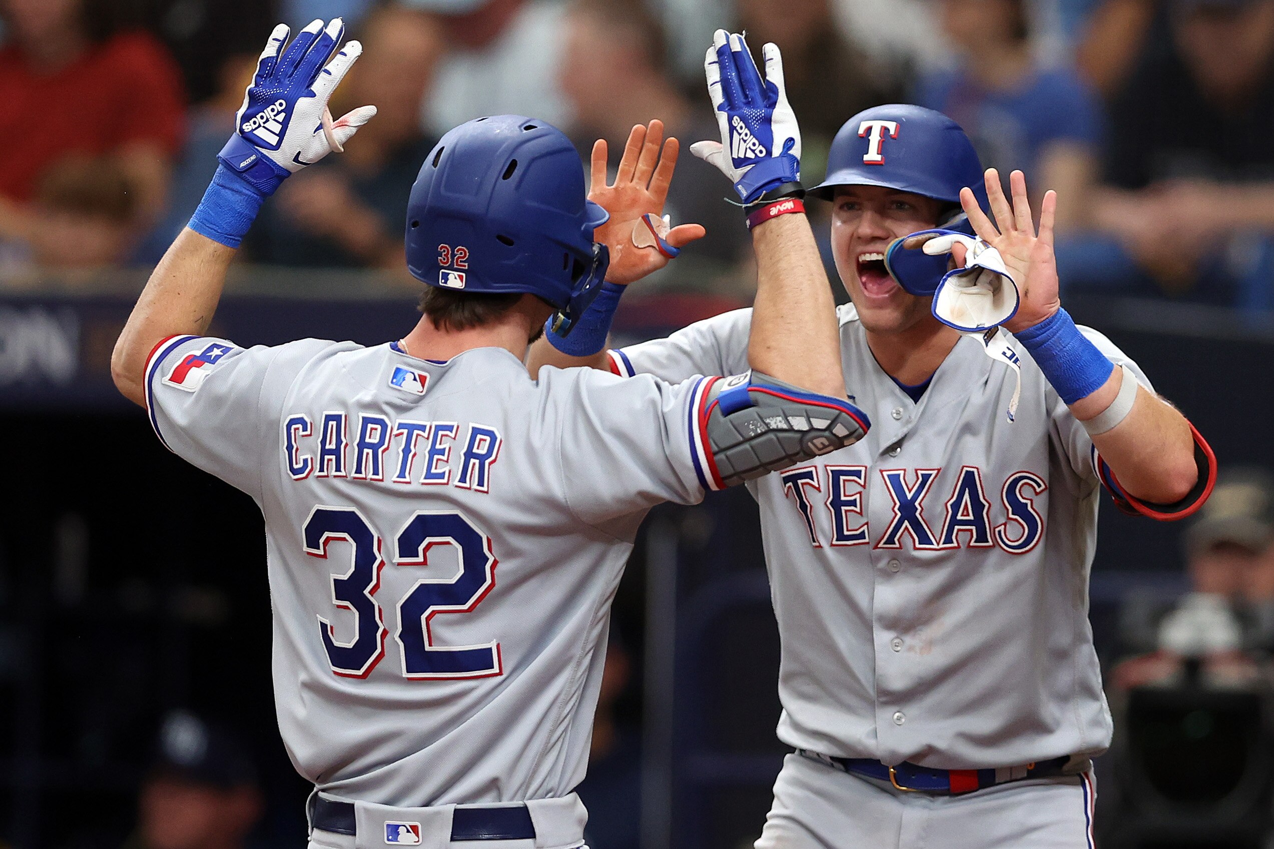 Evan Carter of the Rangers gets high-fives from Josh Jung after Carter's two-run homer in the fourth inning.