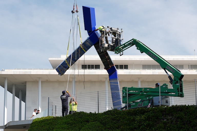 Workers remove the sculpture "Blue" by artist Joel Shapiro on the grounds of the John F. Kennedy Center for the Performing Arts in Washington, Wednesday, Sept. 2, 2026.