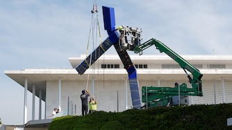 Workers remove the sculpture "Blue" by artist Joel Shapiro on the grounds of the John F. Kennedy Center for the Performing Arts in Washington, Wednesday, Sept. 2, 2026.