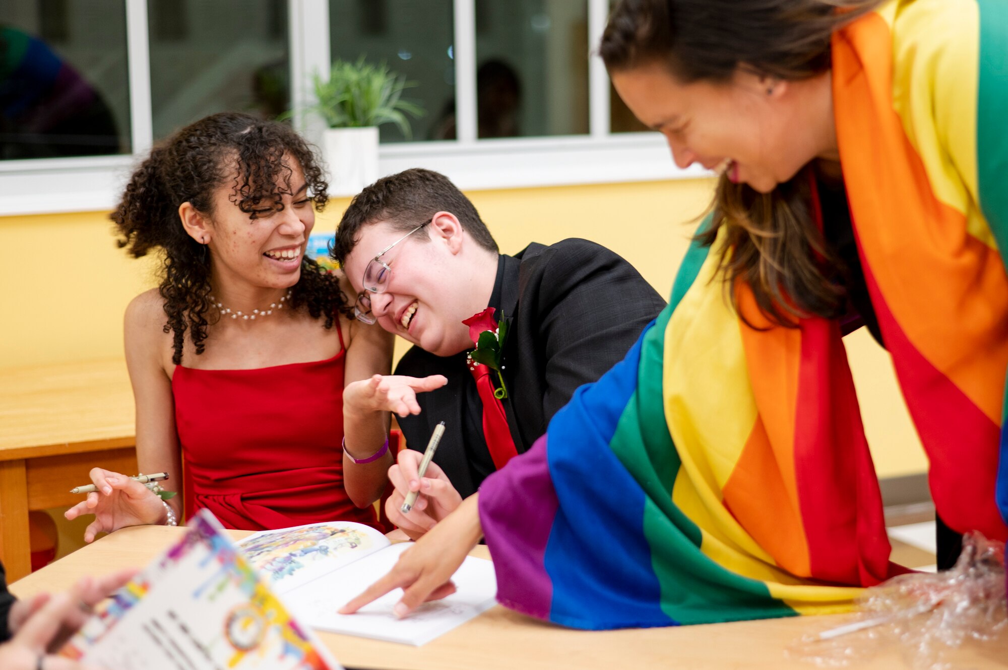 Ariel Long, 15, Christopher Loughery, 16, and Sasha Knight enjoy coloring during Pride Prom at the Harriet Tubman Cultural Center in Columbia on June 10, 2023.
