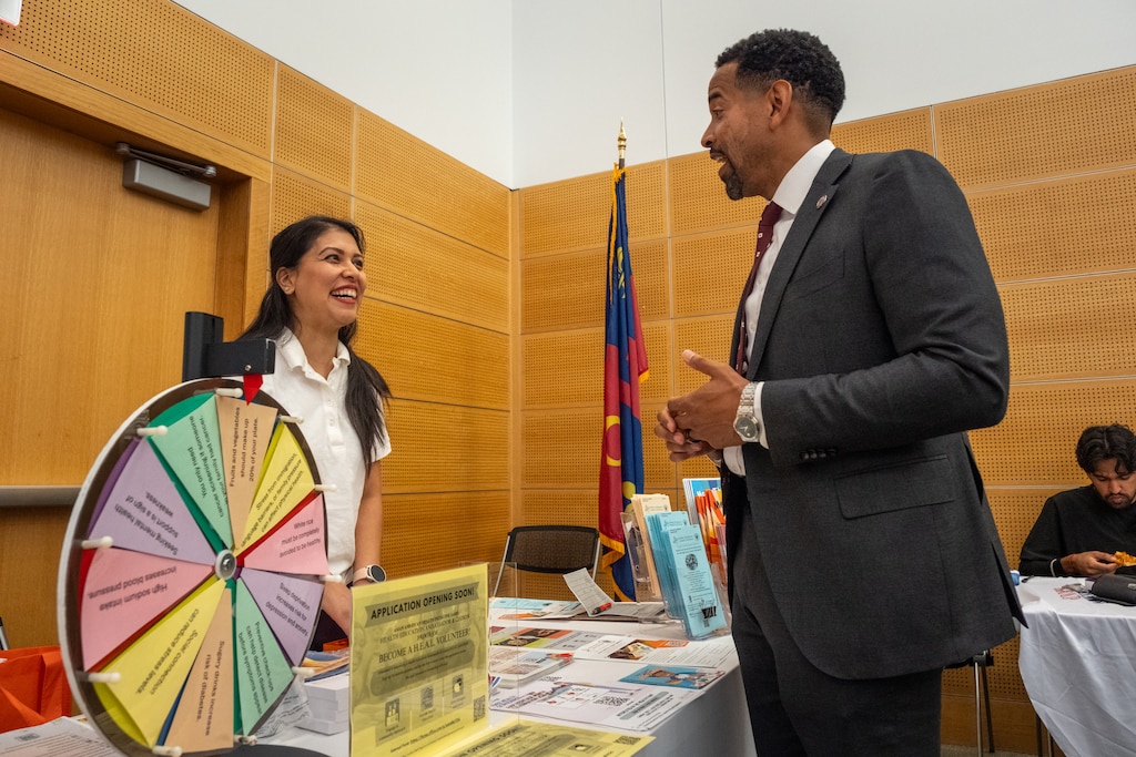 Will Jawando (right), one of three County Council members running for county executive in Montgomery County, speaks with Samikshya Sapkota (left) of the Asian American Health Initiative at a Community Wellness and Resource Fair held by Rep. April McClain Delaney and the American Diversity Group at Montgomery College in Germantown, Md.
