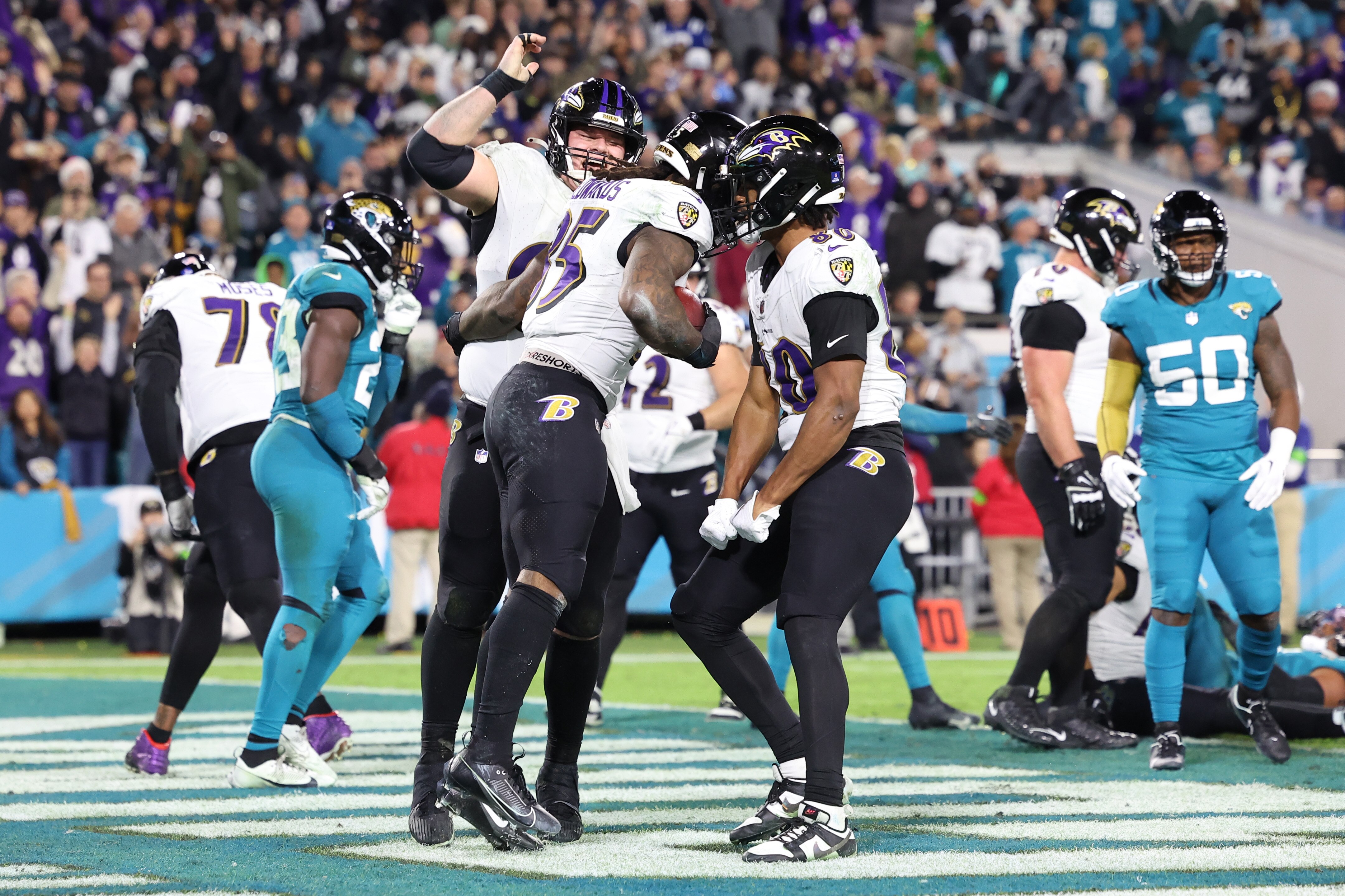 Teammates rush Ravens running back Gus Edwards after his fourth-quarter touchdown Sunday night at Jacksonville.