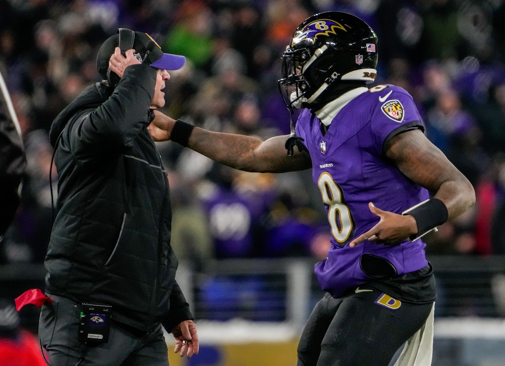 Baltimore Ravens quarterback Lamar Jackson (8) runs to the sideline to talk with Head Coach John Harbaugh during the fourth quarter against the Houston Texans at M&T Bank Stadium on Saturday, Jan. 20, 2024.
