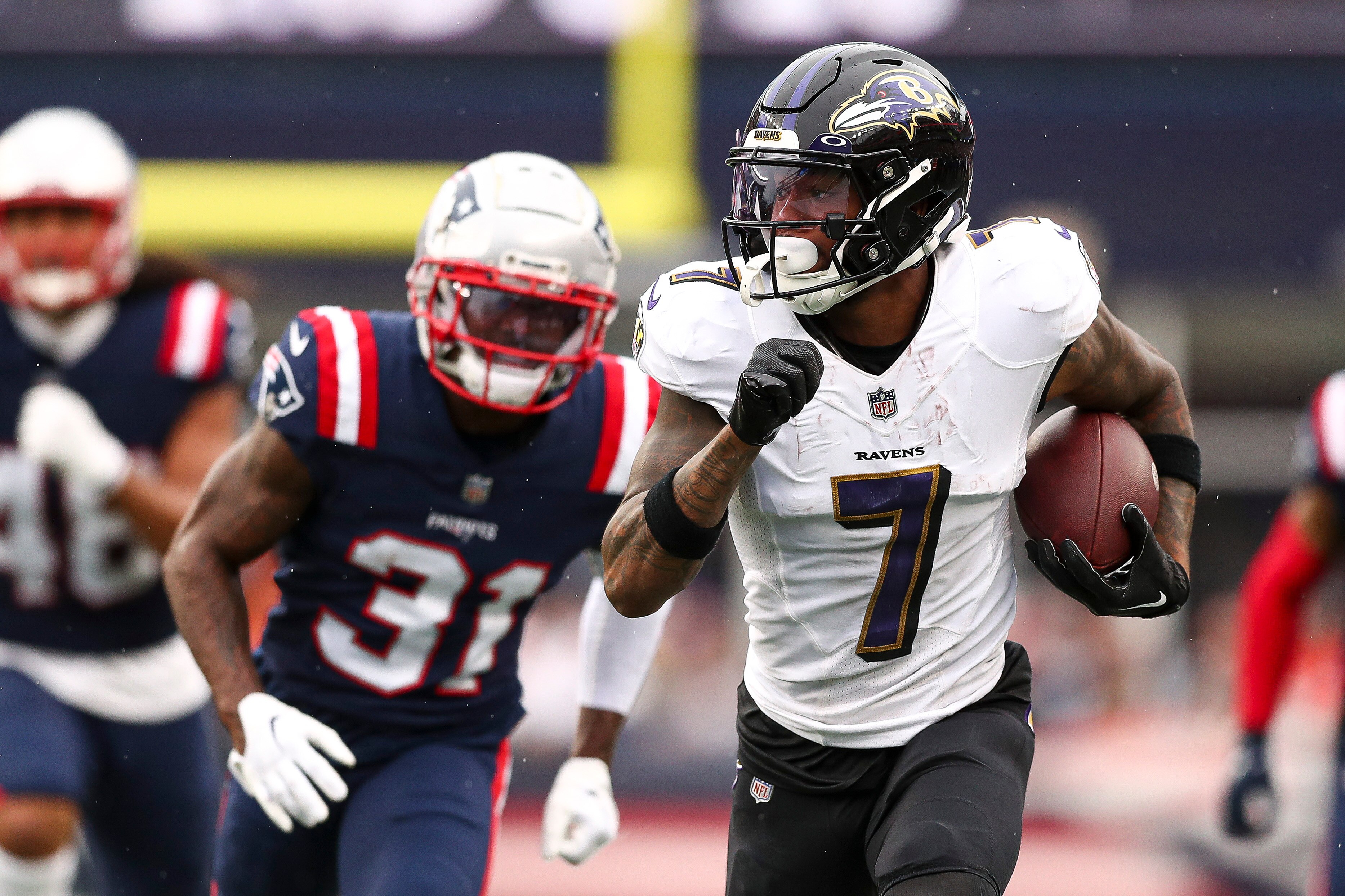 FOXBOROUGH, MASSACHUSETTS - SEPTEMBER 25: Wide receiver Rashod Bateman #7 of the Baltimore Ravens runs upfield while cornerback Jonathan Jones #31 of the New England Patriots pursues during the fourth quarter at Gillette Stadium on September 25, 2022 in Foxborough, Massachusetts.