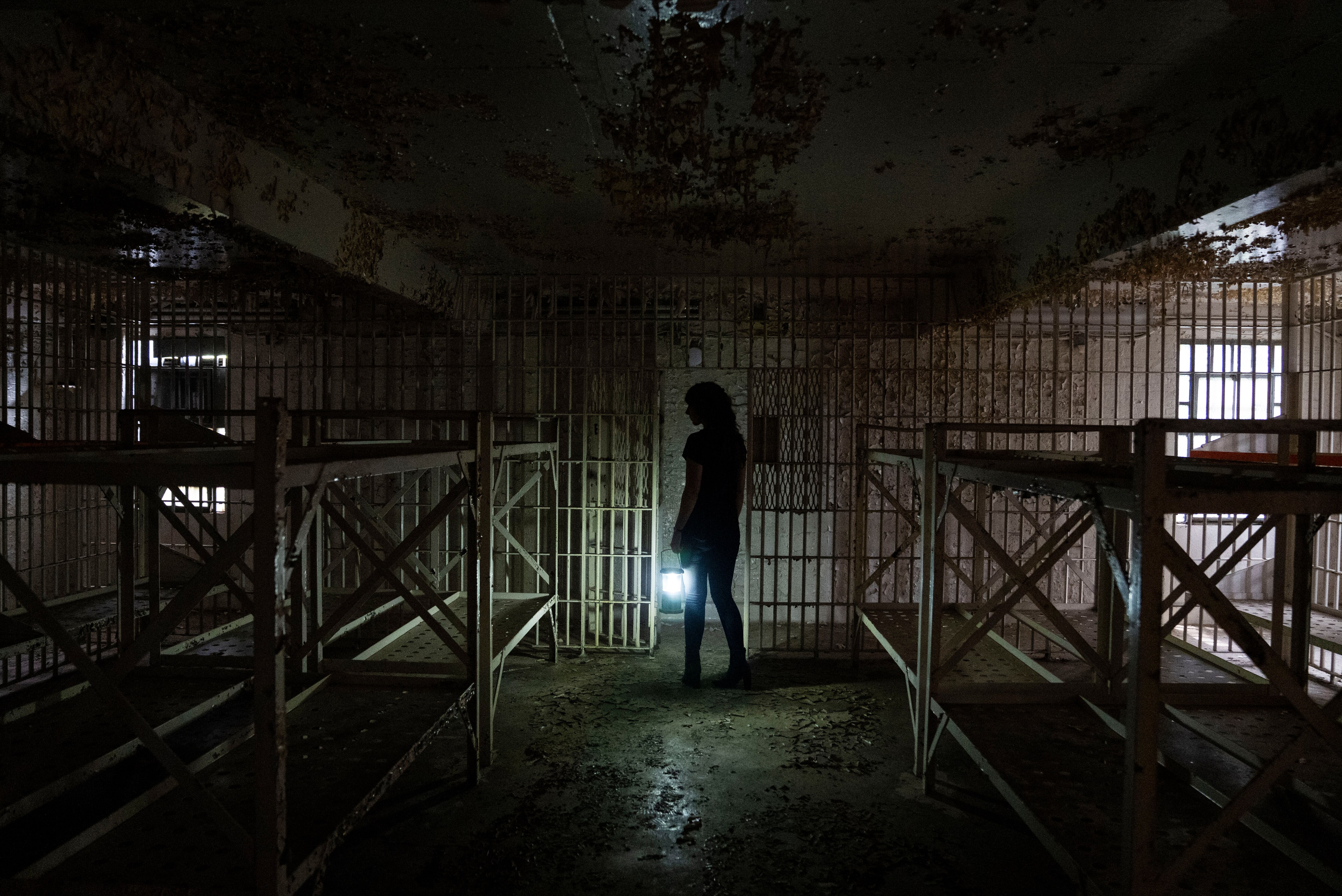 Laura Houston, Preservation Maryland’s director of revitalization initiatives, holds a flashlight during a tour of the old Ellicott City Jail.