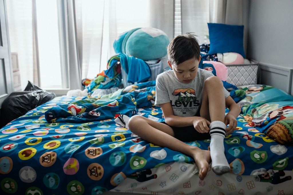 HAGERSTOWN, MD - July 22, 2026: Jacob Hoang, 11, gets ready for summer camp in his parent’s bedroom in Hagerstown, Maryland on July 22, 2026. Jacob and his sister, Riley, moved into their dad, Danny’s, bedroom after their mother, Melissa, was deported to Vietnam. Rosem Morton for The Baltimore Banner