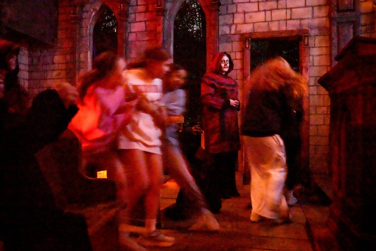 Banner reporter Hannah Yasharoff, center, scares visitors passing through the church scene at Markoff's Haunted Forest in Dickerson, Md. on Friday, October 9, 2026.