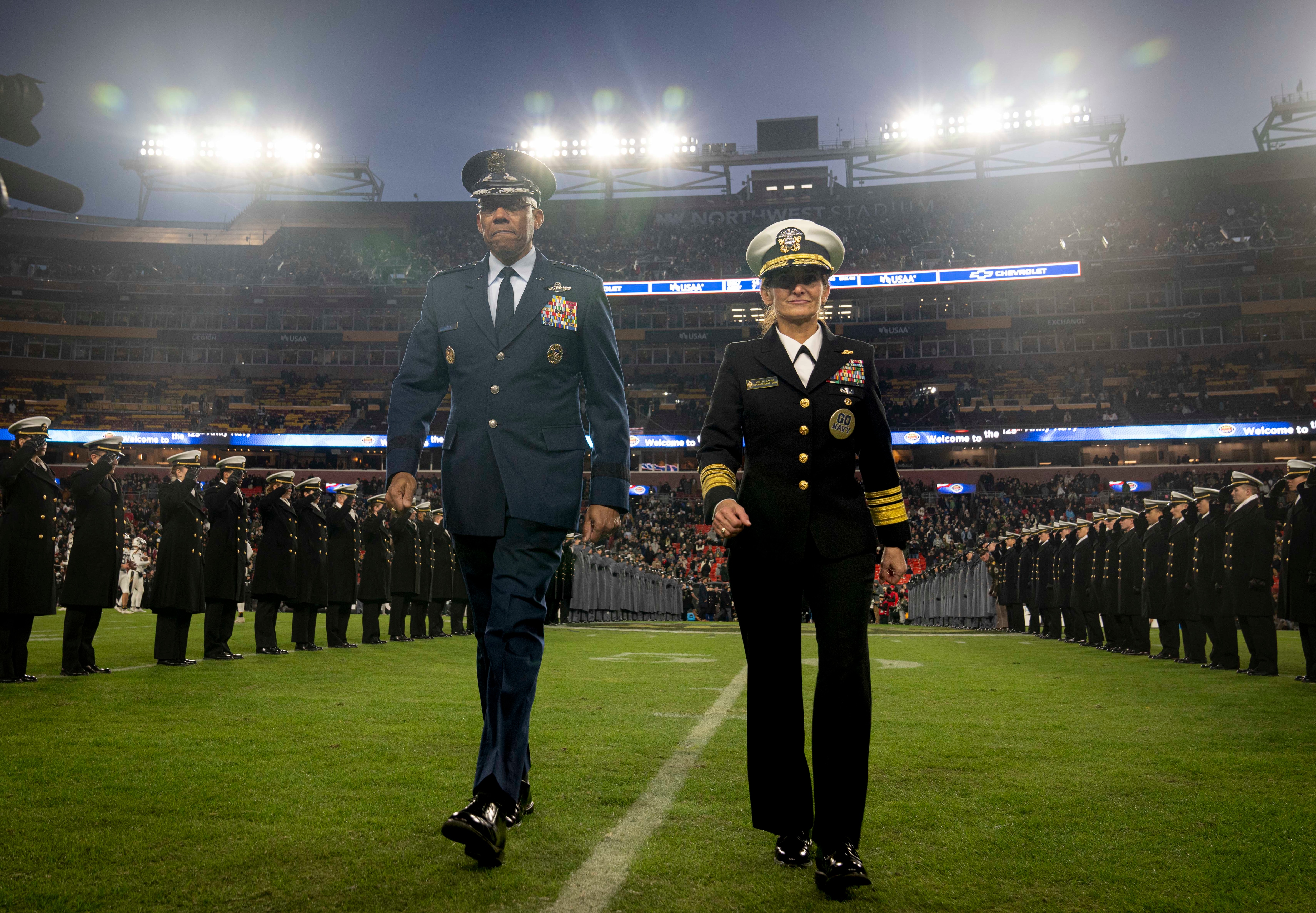 Gen. CQ Brown, Jr., Chairman of the Joint Chiefs of Staff, crosses the field at halftime Vice Adm. Yvette Davids, Superintendent of the U.S. Naval Academy, during the 2024 Army-Navy Game at Northwest Stadium in Landover, MD, December 14, 2024.