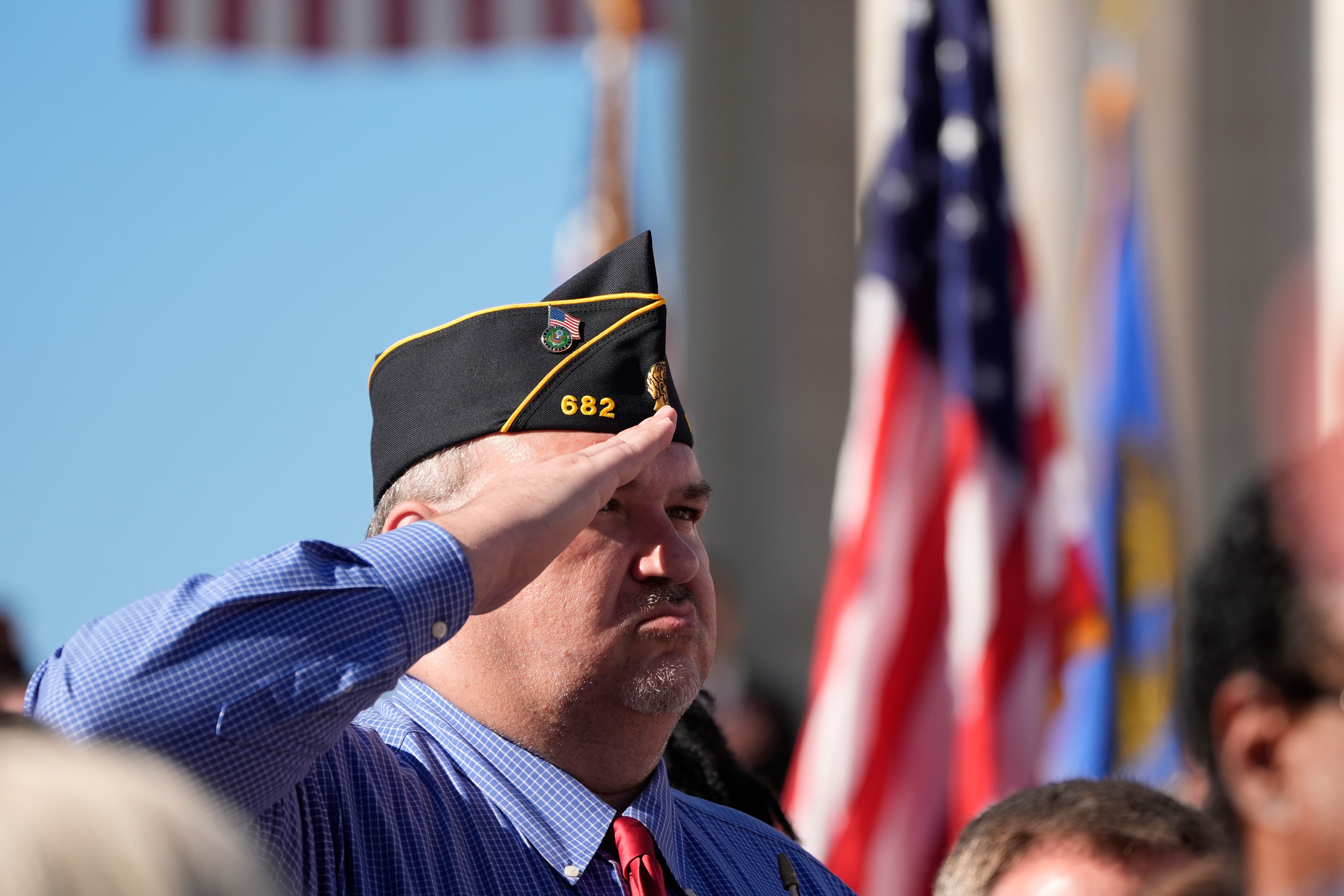 An attendee salutes at the National Veterans Day Observance at the Memorial Amphitheater at Arlington National Cemetery in Arlington, Va., Monday, Nov. 11, 2024. (AP Photo/Mark Schiefelbein)