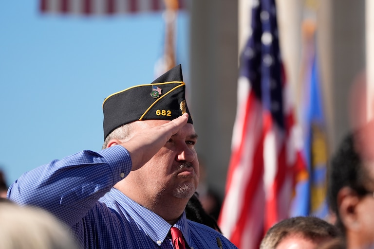 An attendee salutes at the National Veterans Day Observance at the Memorial Amphitheater at Arlington National Cemetery in Arlington, Va., Monday, Nov. 11, 2024. (AP Photo/Mark Schiefelbein)
