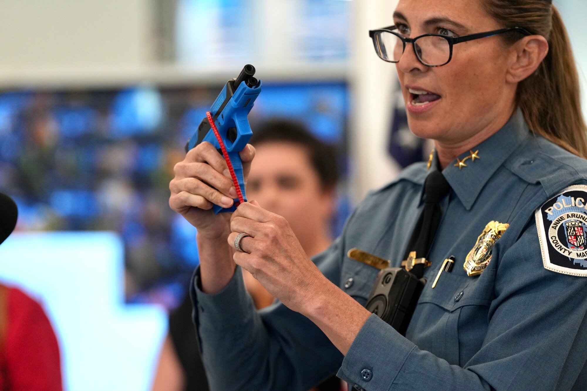 Deputy Chief Roberts demonstrates how to use the gun safety lock a press conference hosted by County Executive Steuart Pittman, Ann Arundel department of Health and the Ann Arundel County Public library on April 13, 2023.