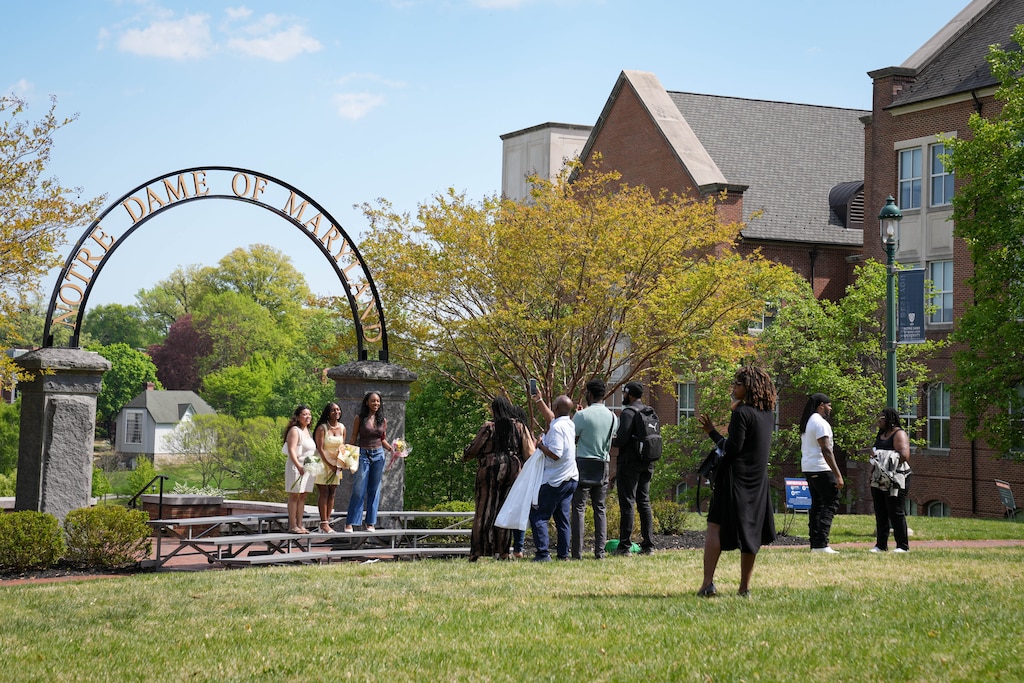 Students are photographed by family and loved ones in front of the Notre Dame of Maryland University arch on campus in Baltimore, Md. on Thursday, April 24, 2026.
