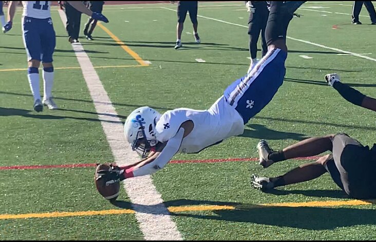 St. Mary's Israel Crockett puts the ball over the end zone for a touchdown during the fourth quarter of Saturday's MIAA B Conference football contest with Archbishop Curley. The No. 7 Saints moved to 8-0 with a 22-3 victory in Baltimore City