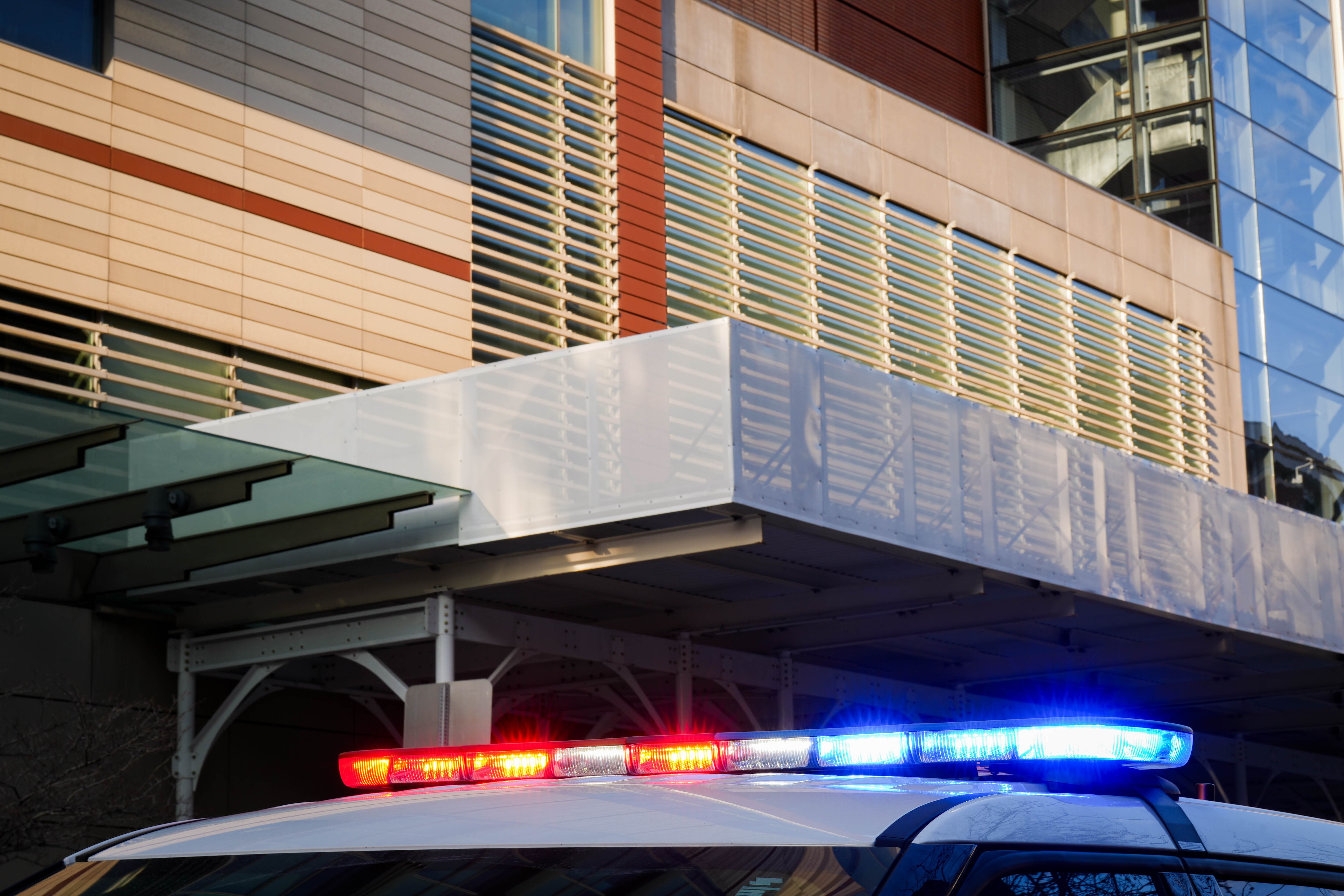 A Baltimore County police vehicle’s lights flash while parked outside of the R Adams Cowley Shock Trauma Center at the University of Maryland in Baltimore, Md. on Thursday, March 13, 2025.