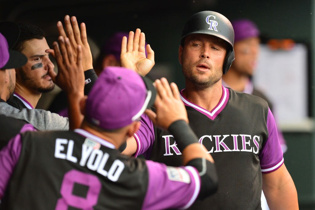 Matt Holliday, #7 of the Colorado Rockies, is congratulated in the dugout after scoring a run in a 2018 game. (Photo by Dustin Bradford/Getty Images)