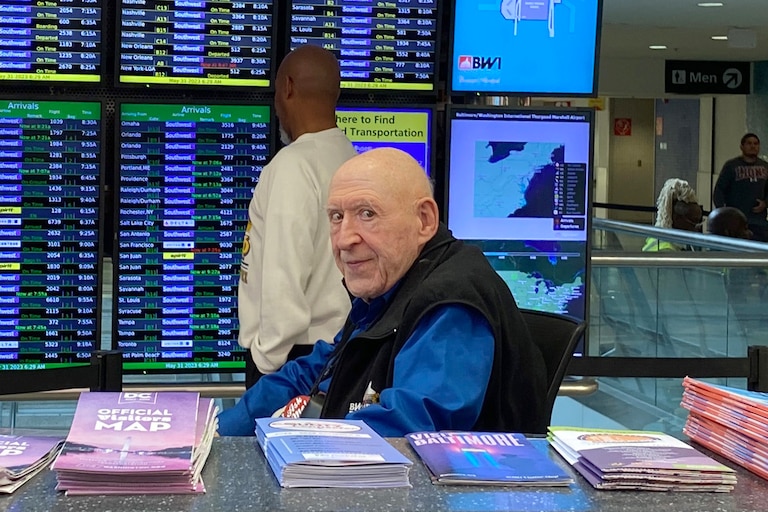 Gus Buchdahl side-eyes a camera from an information desk at BWI Airport in 2023. His grandchildren turned the photo into a sticker on their phones.