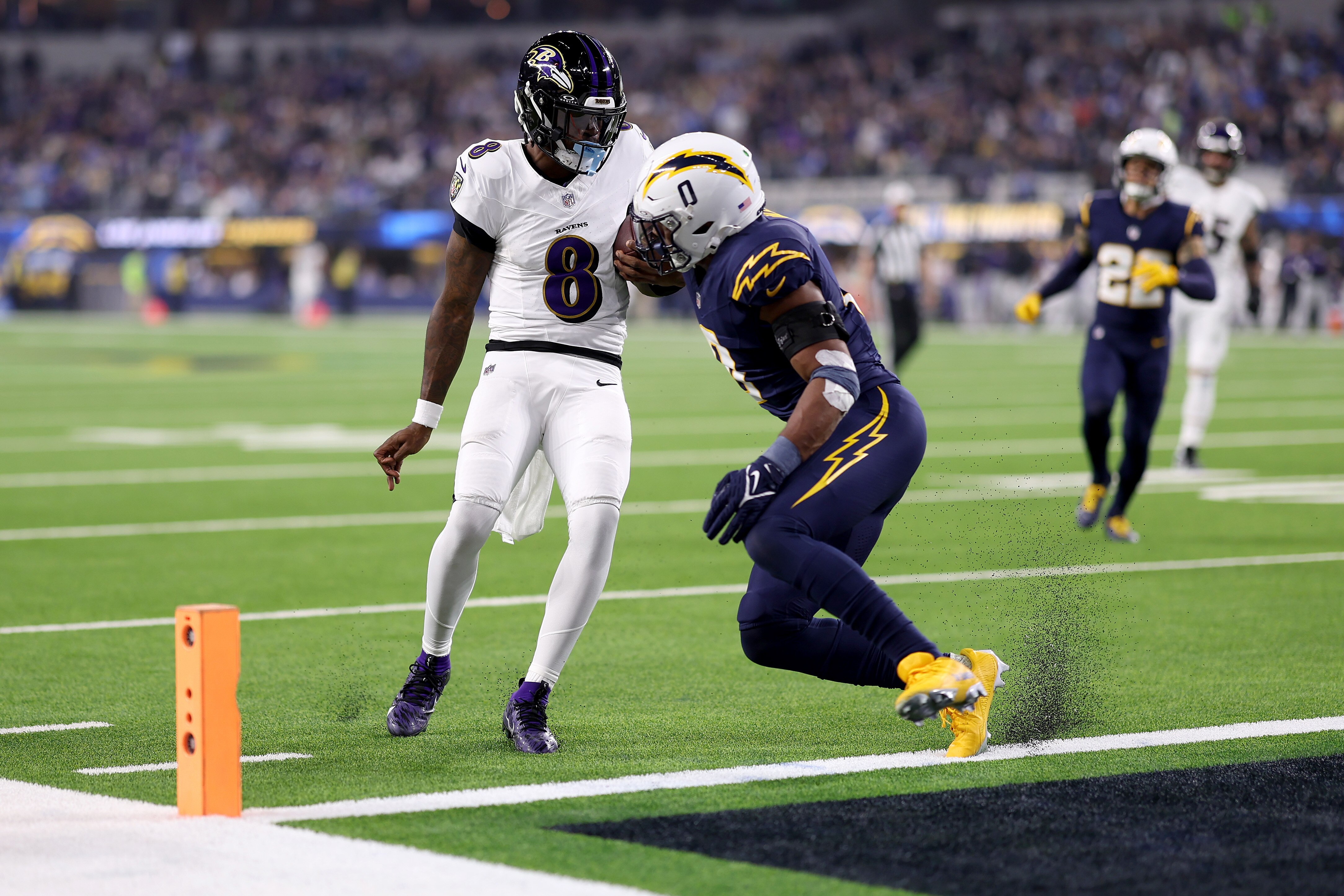 Ravens quarterback Lamar Jackson dodges the tackle of the Chargers’ Daiyan Henley to second a 10-yard touchdown in the second quarter.