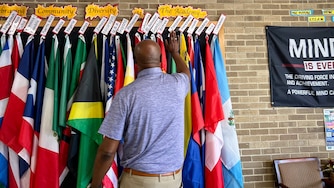 Andrew Jackson Academy Principal Warren Tweedy shows off hallway flags representing the home countries of his students and their families.
