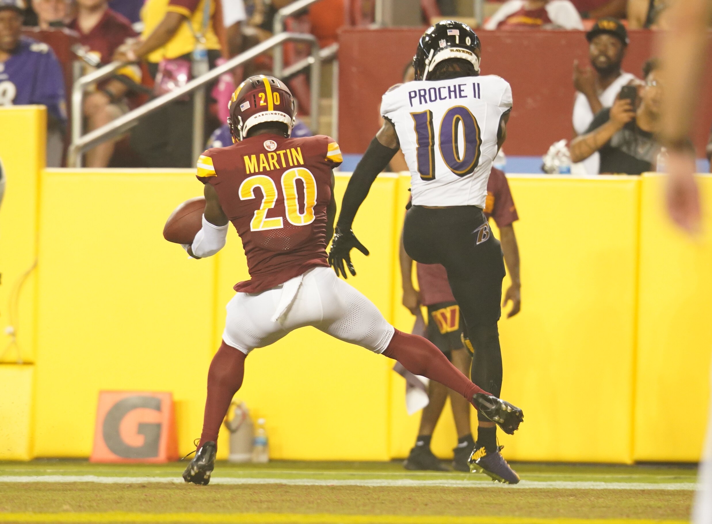 Washington Commanders safety Jartavius Martin (20) intercepts a pass intended for Baltimore Ravens wide receiver James Proche II (10) during a preseason game against the Washington Commanders at FedEx Field on Monday, August 21, 2023.