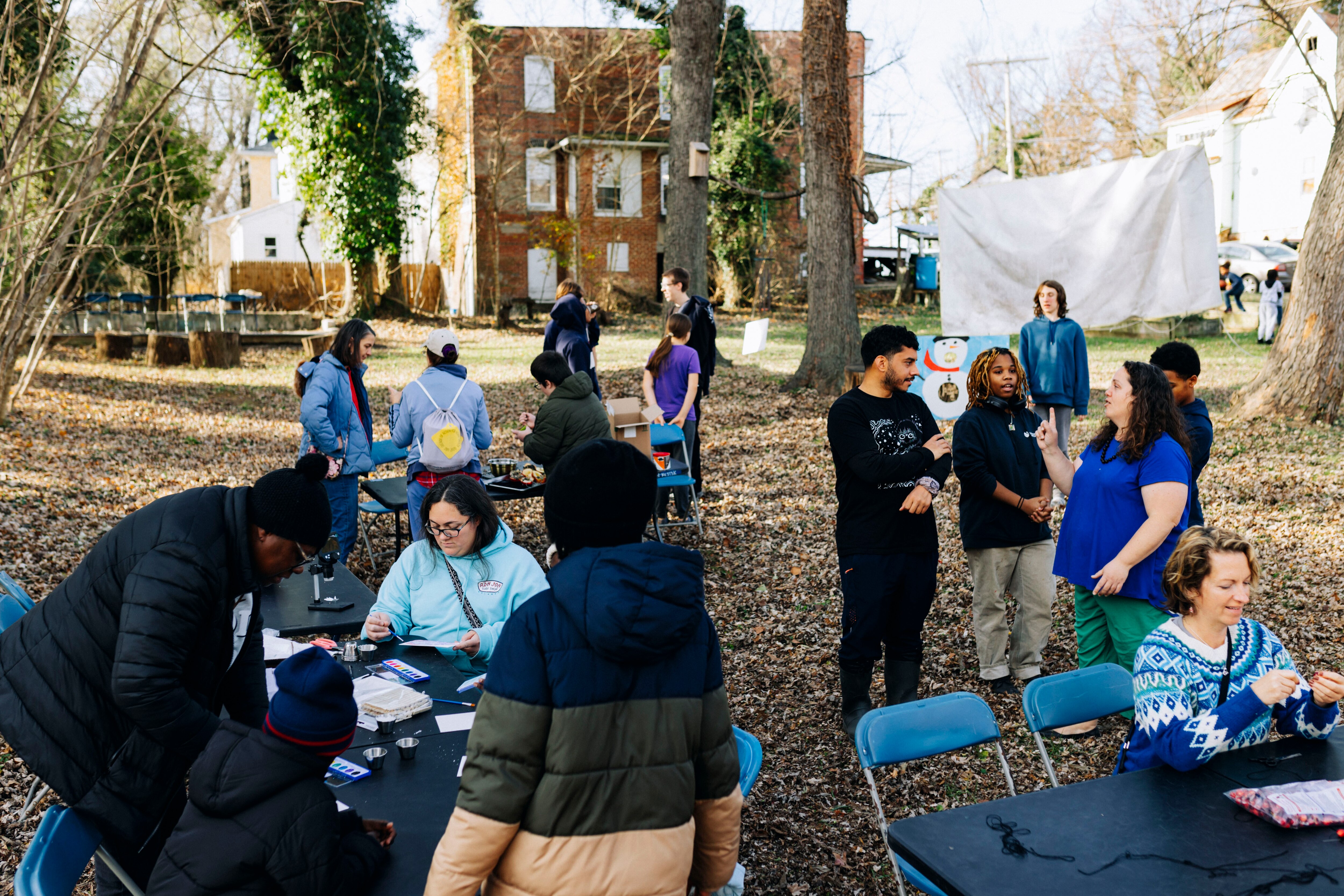 Neighbors talk, paint and make cranberry garlands during the Winter Forest Garden Festival in the Collins Streamside Community of Baltimore, MD on Sunday, Dec. 8, 2024.