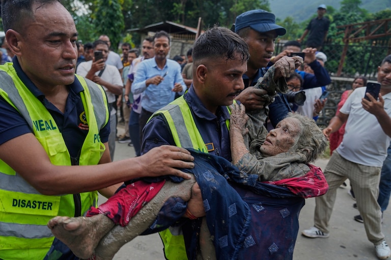 Rescuers carry a victim of flash flooding to safety along the Trishuli River in Nepal's Nuwakot district, Wednesday, Aug. 26, 2026. (AP Photo/Niranjan Shrestha)