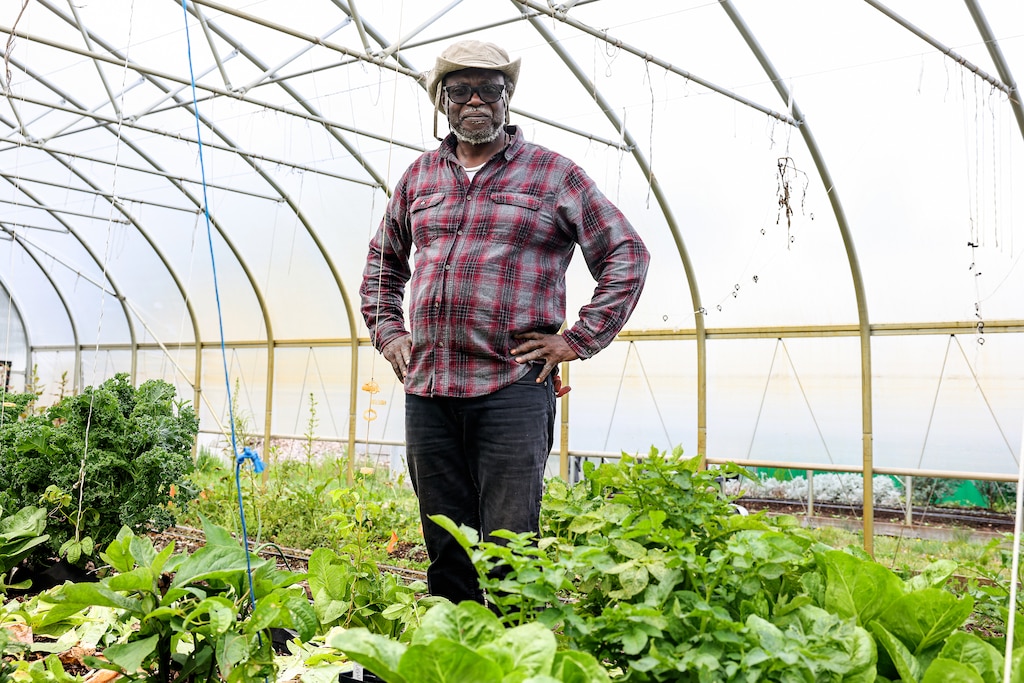 Farmer Isaac Zama, who operates Asawana Farms, stands next to his seedlings at the Urban Farm Incubator at Watkins Regional Park in Upper Marlboro